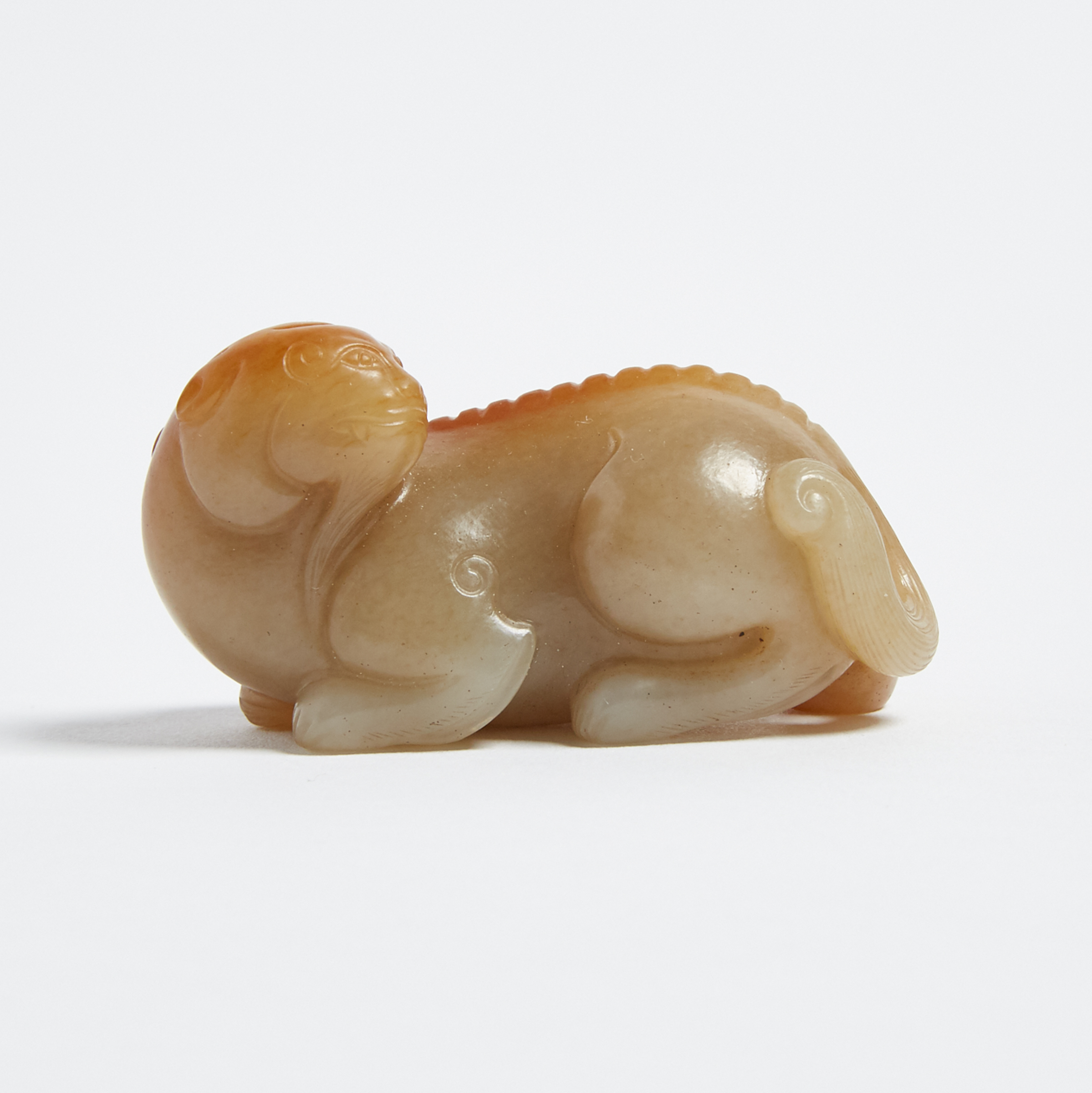 A Pale Celadon and Russet Jade Carving of a Lion