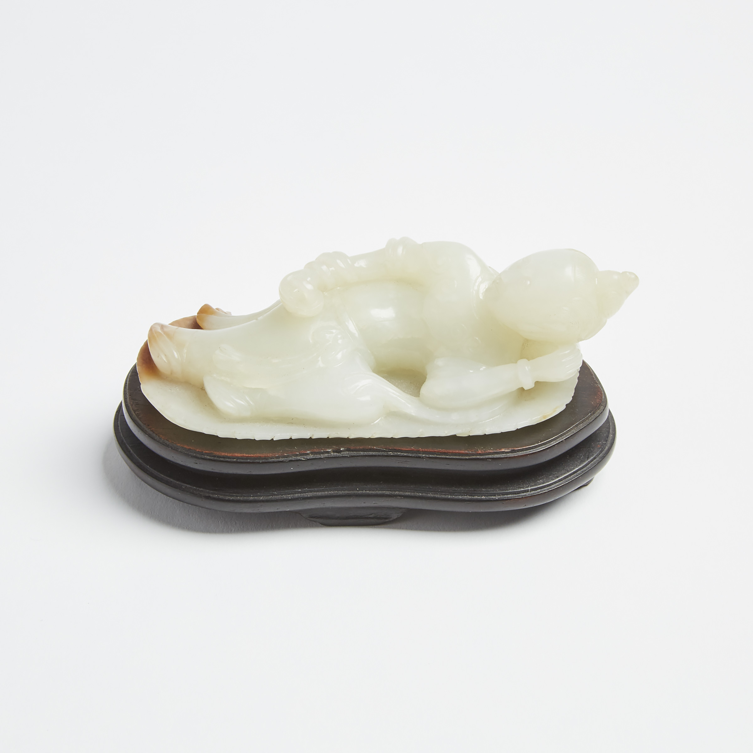 A White and Russet Jade Carving of a Reclining Figure