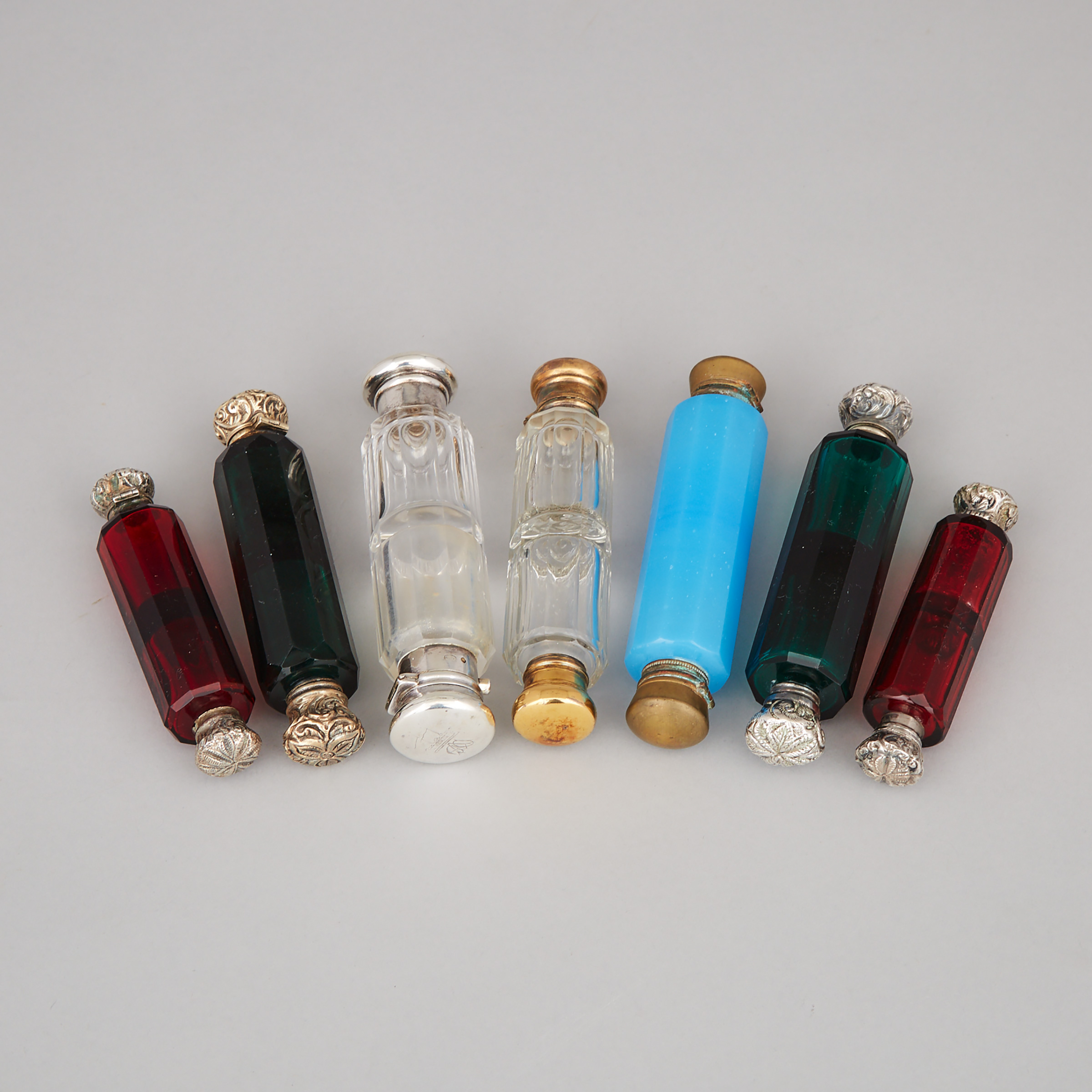 Seven Silver and Metal Mounted Red, Green, Opaque Blue and Clear Glass Double-Ended Perfume Phials, late 19th century