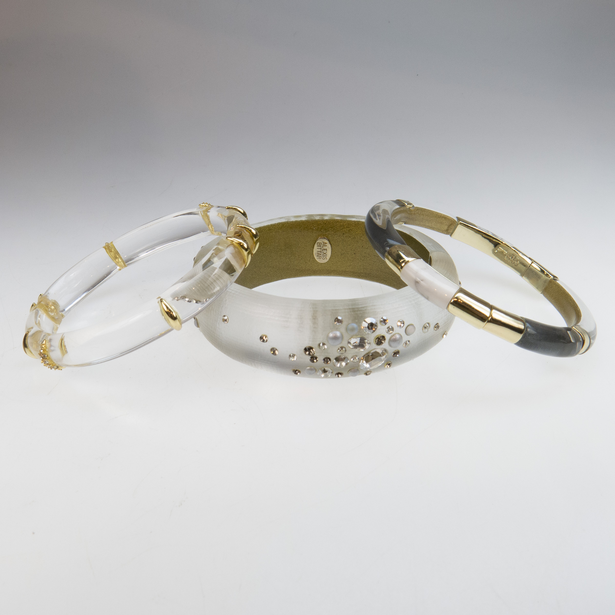 Three Alexis Bittar Clear Lucite And Gold Tone Metal Spring Hinged Bangles