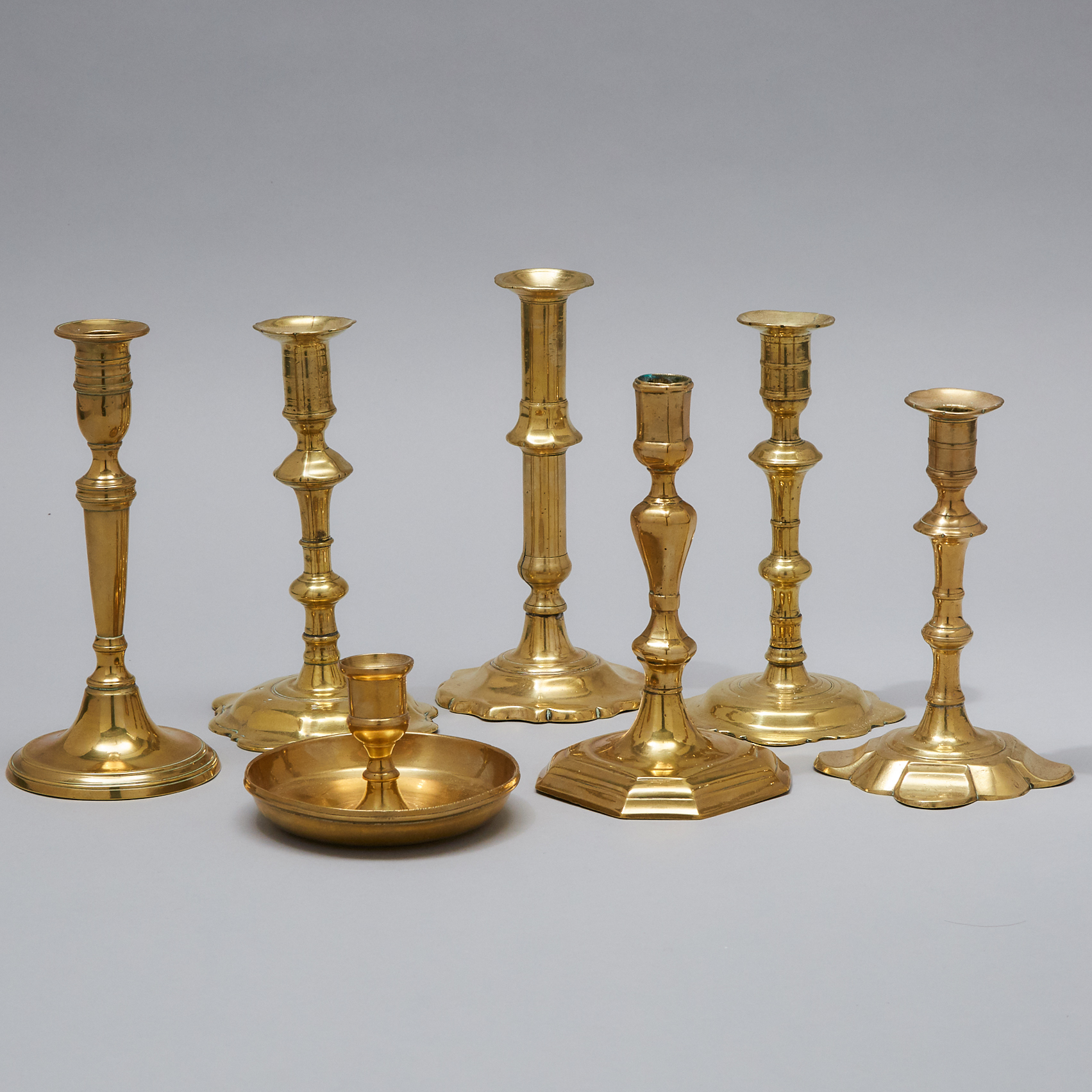 Six Mainly English Brass Candle Sticks and a Chamber Stick, early 18th century
