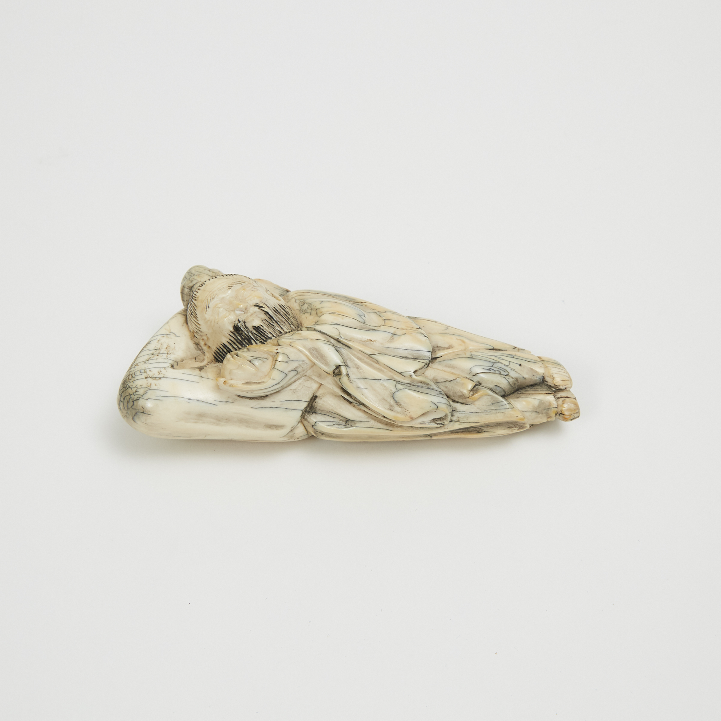 An Ivory Carved Figure of a Reclining Sage