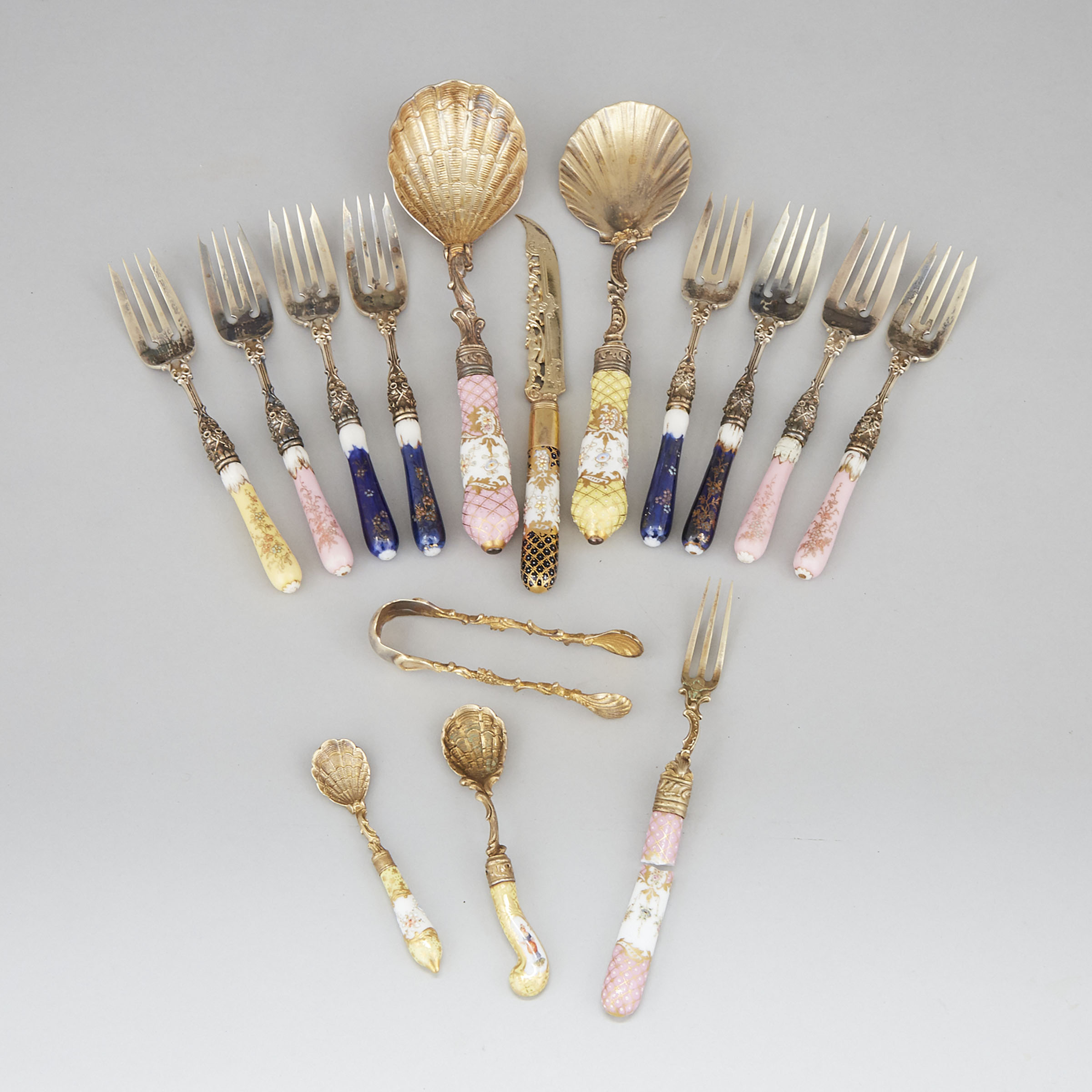Two German Porcelain Handled Silver-Gilt Serving Spoons, Dessert Knife, Nine Forks, Two Salt Spoons and Complementary Sugar Tongs, c.1900