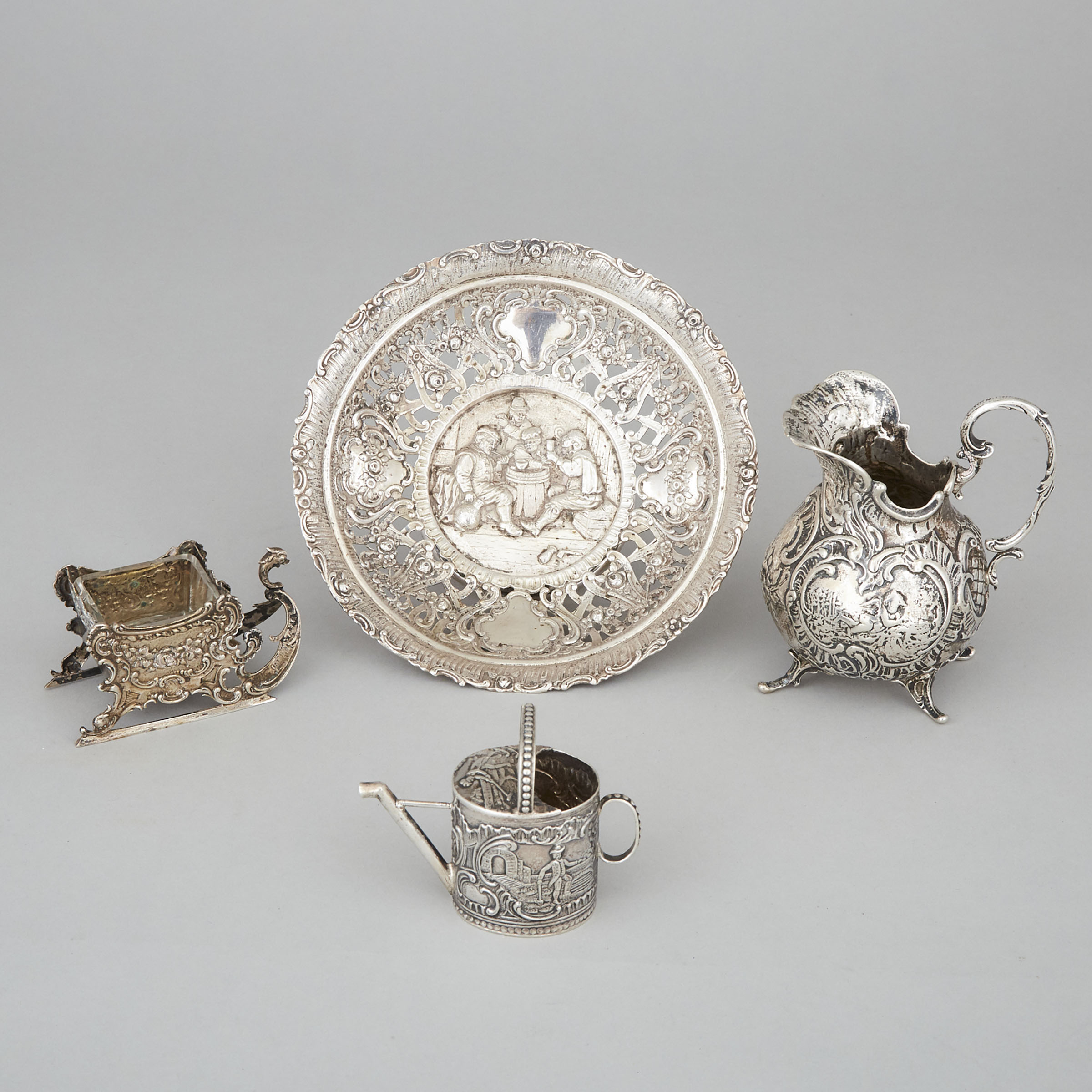 German Silver Cream Jug, Circular Dish, Sleigh-Form Salt Cellar and a Miniature Watering Can, Hanau, early 20th century
