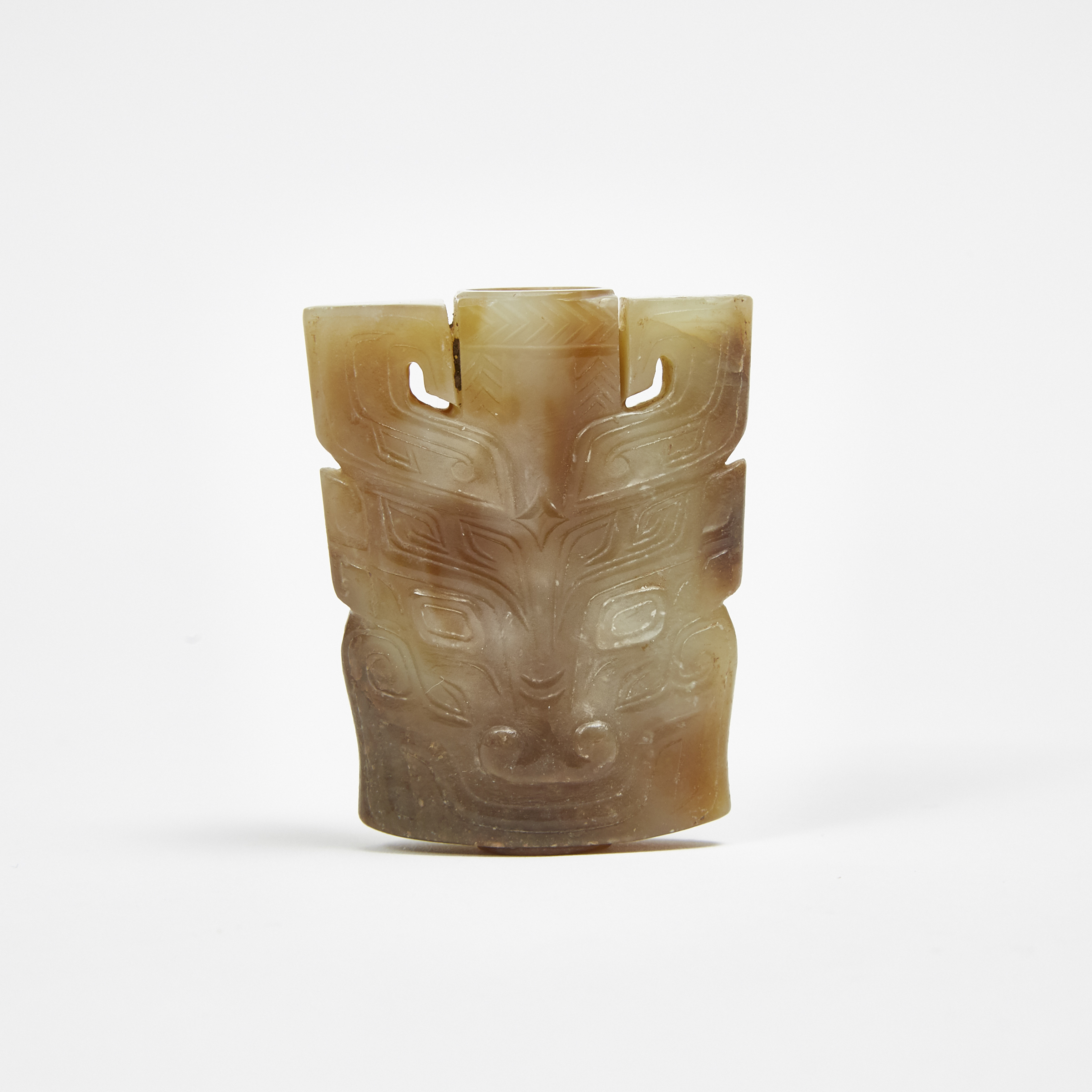 A Celadon and Russet Jade Archaic-Style Sword Pommel With Taotie Patterns
