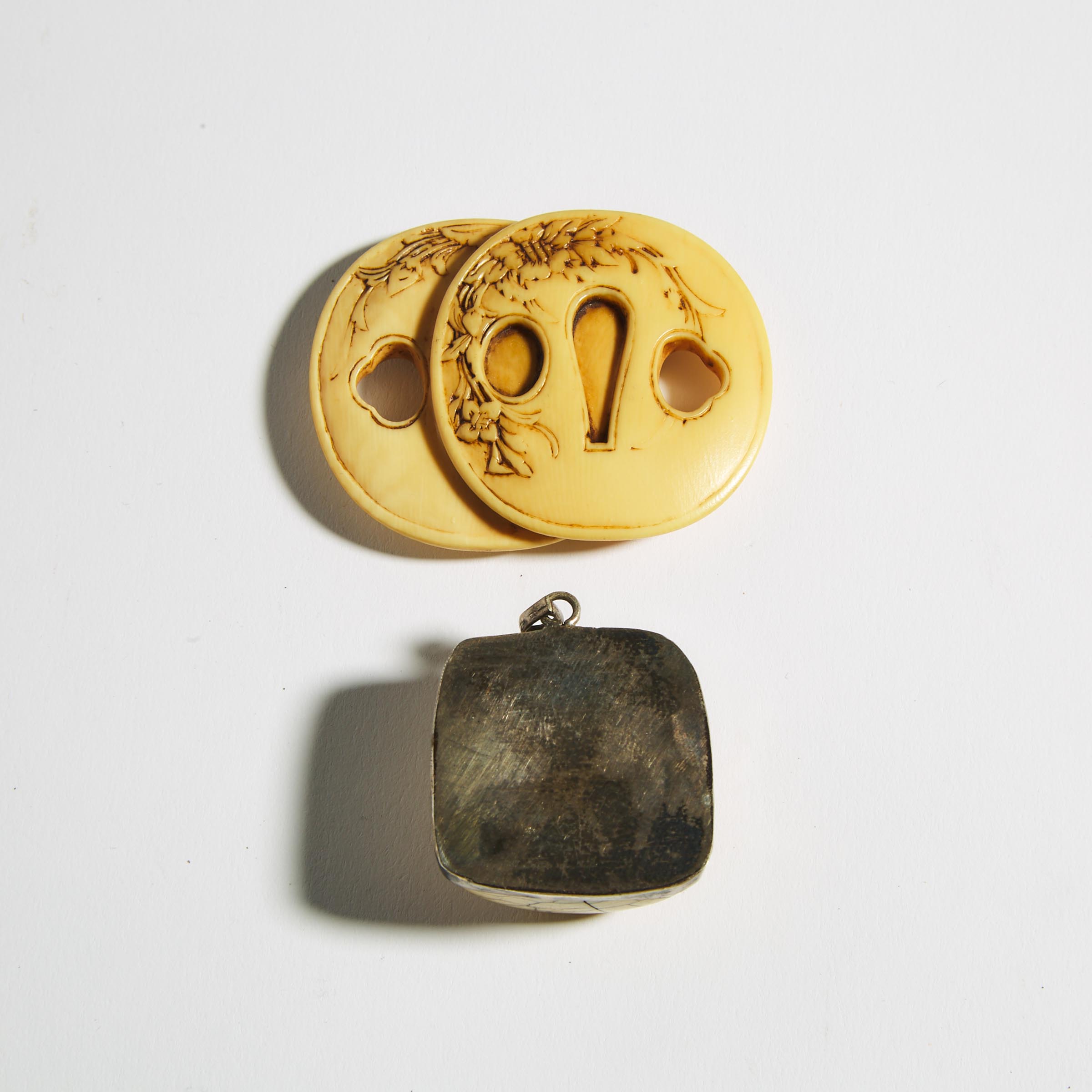 An Ivory Netsuke of a Pair of Tsuba, together with an Metal-Mounted Toggle, Meiji Period