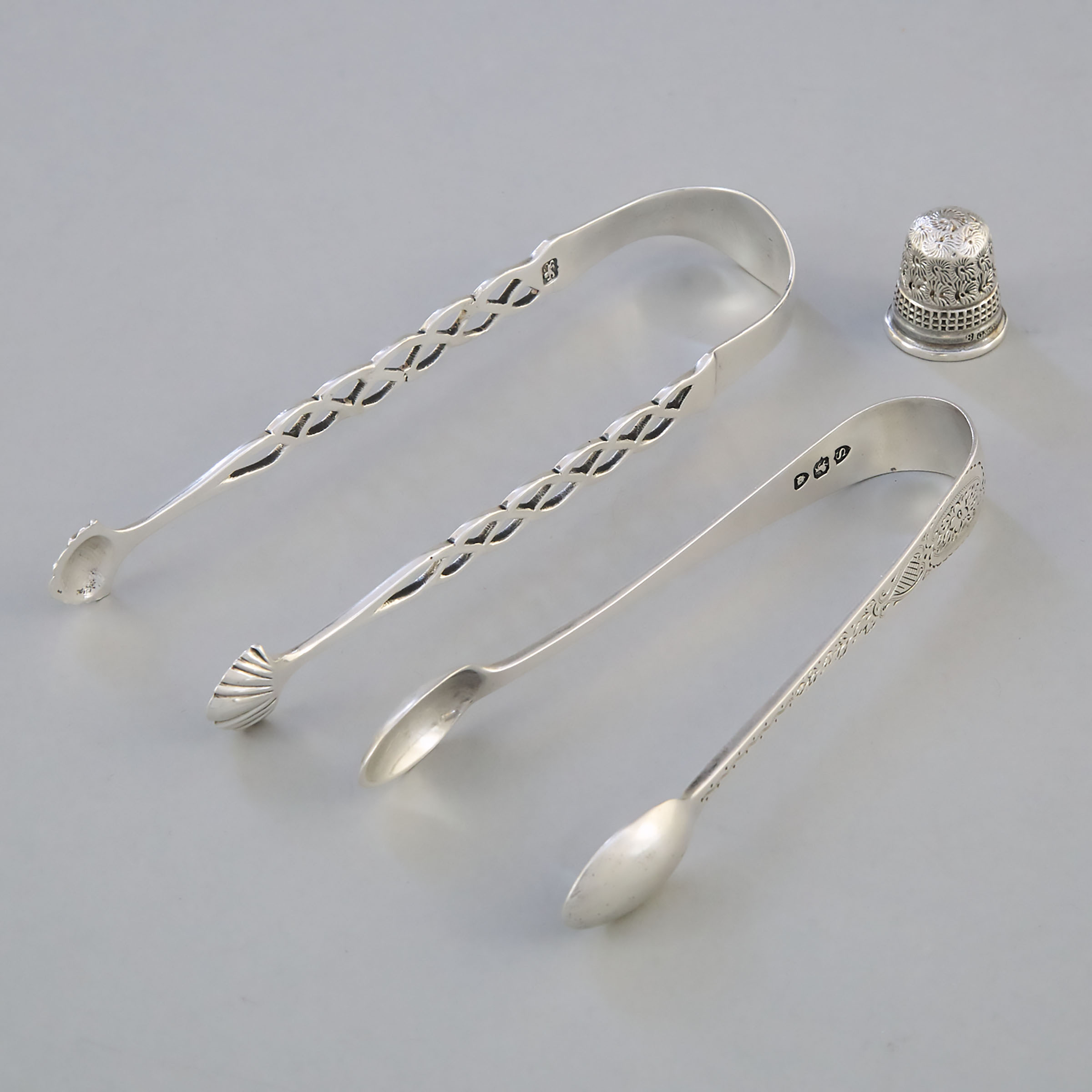 Two George III and Victorian Silver Sugar Tongs, London, c.1775/1893, and a Thimble, Chester, 1896