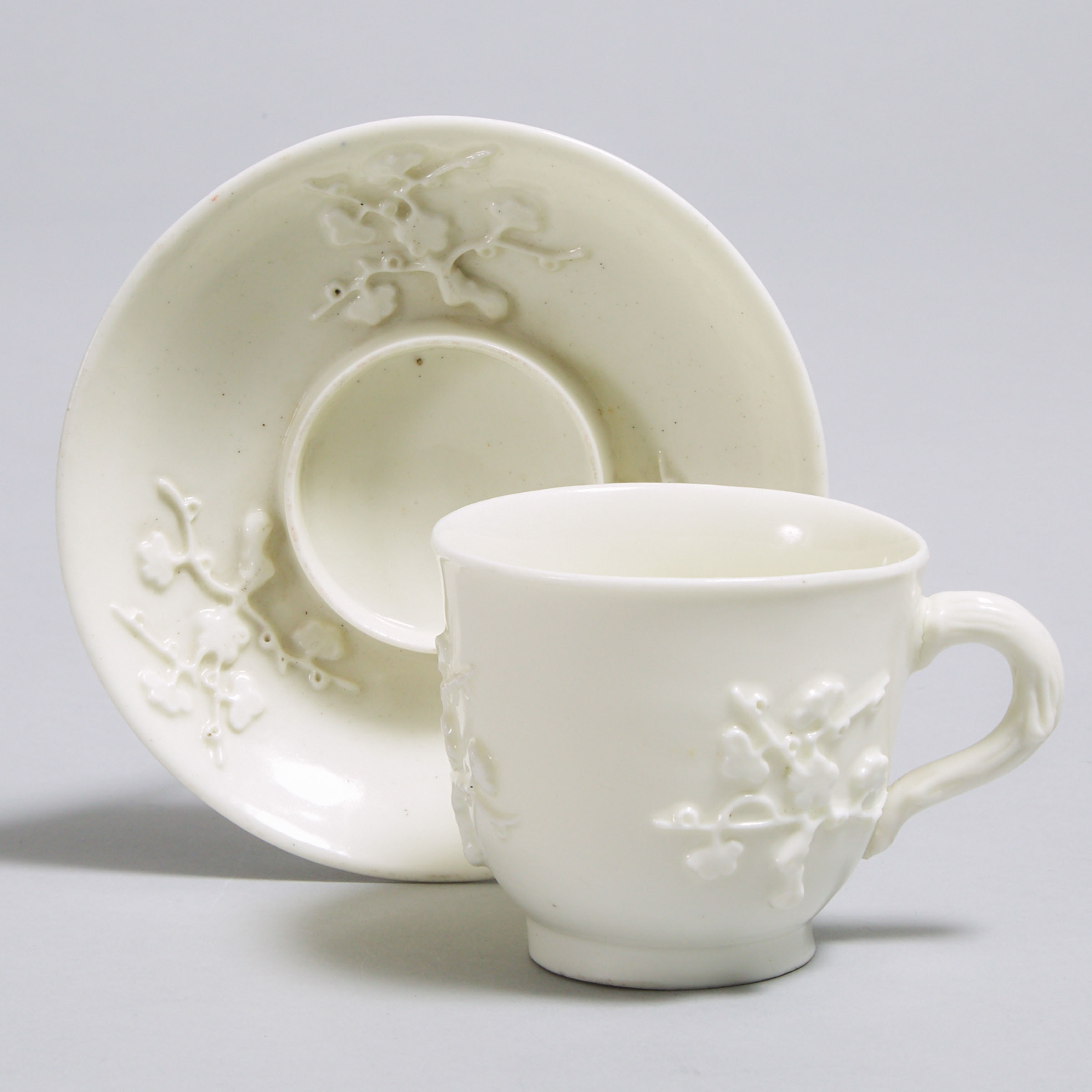 Saint-Cloud Moulded and White Glazed Prunus Trembleuse Cup and Saucer, c.1725