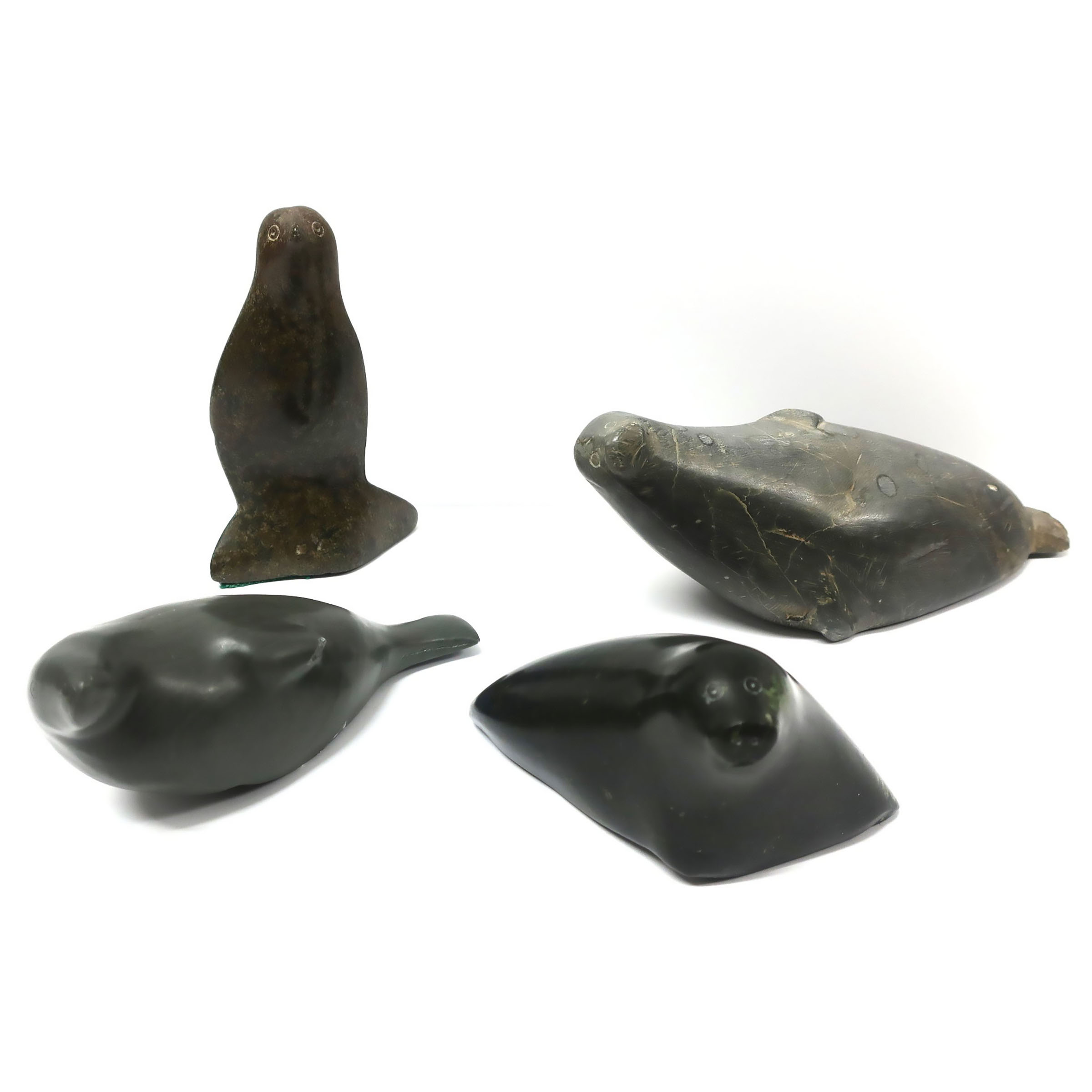 A COLLECTION OF FOUR INUIT SEAL SCULPTURES AND A BIRD