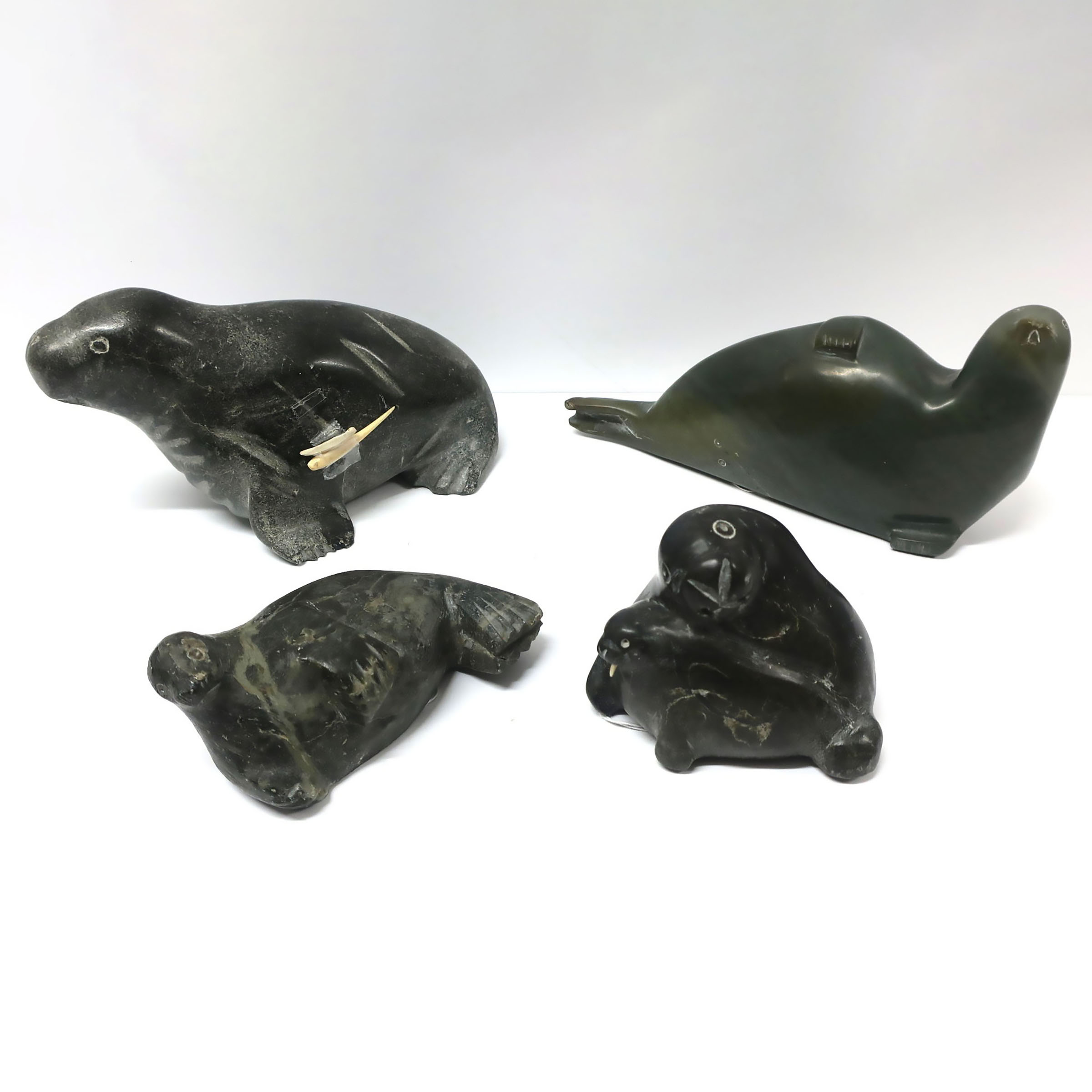 A COLLECTION OF FOUR INUIT CARVINGS OF SEALS AND WALRUS