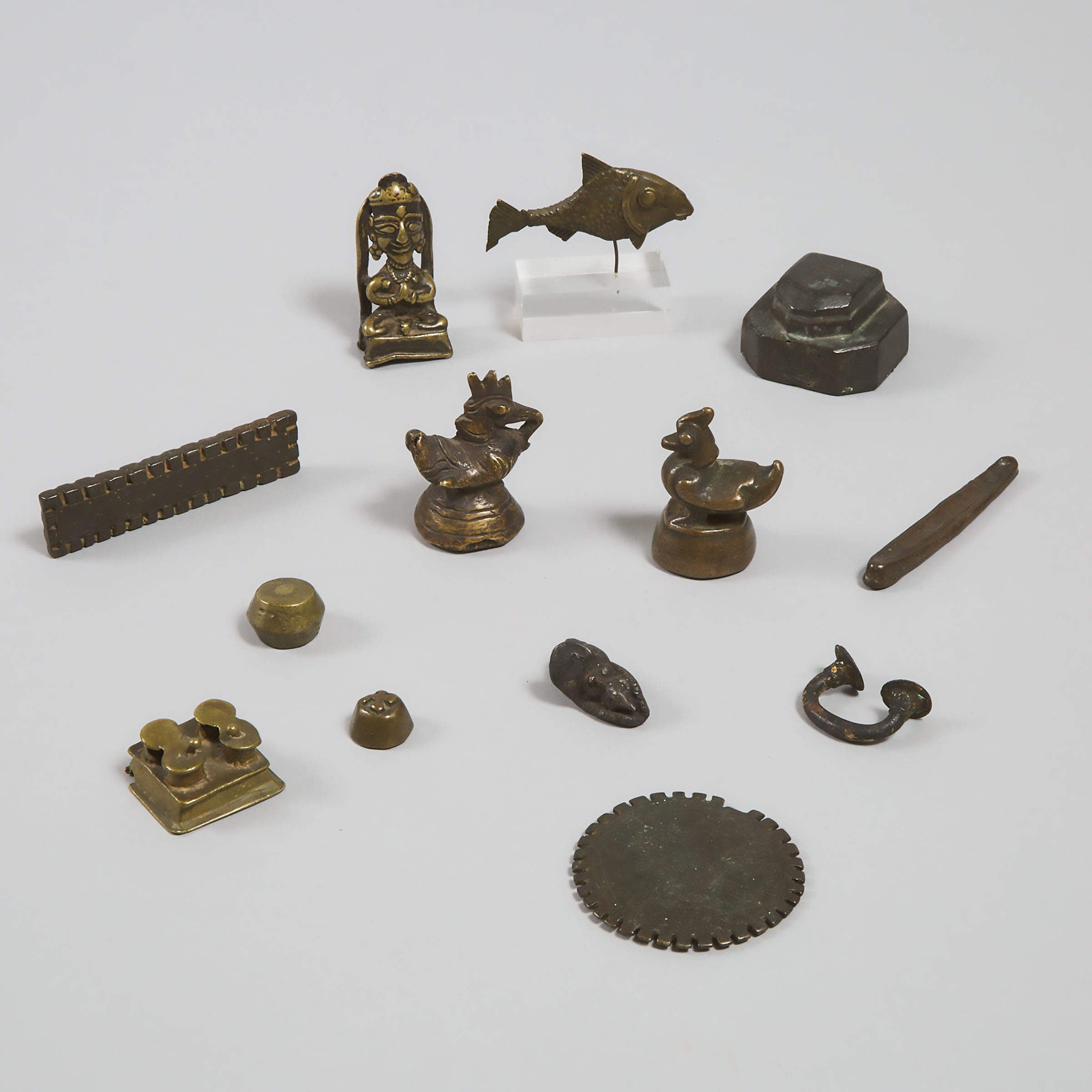 11 Mostly Ashanti Bronze Gold Weights, a West African Gilt Bronze Manilla, and a Laos 'Boat Money' Bronze Ingot, 19th/early 20th century
