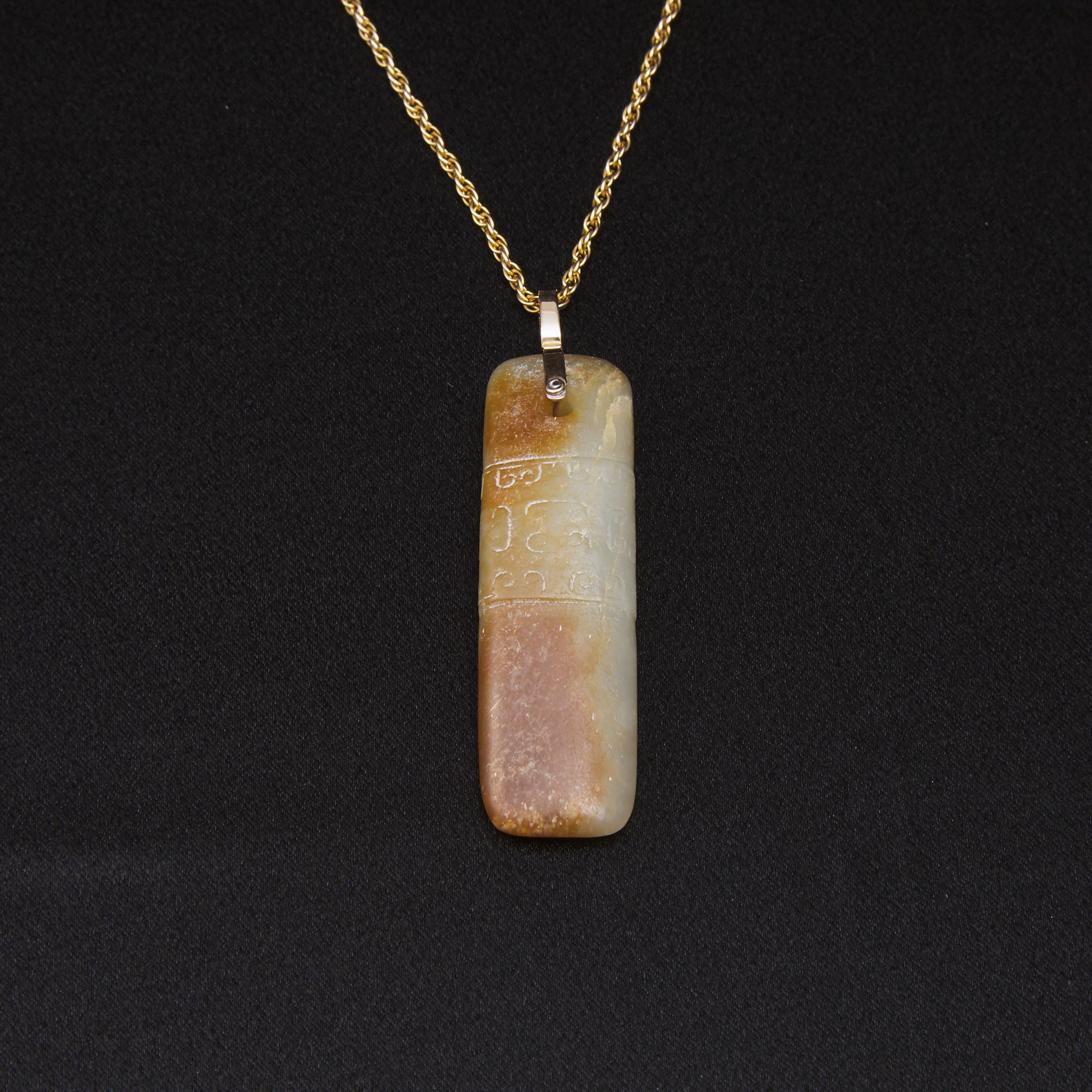 A White and Russet Jade Axe-Form Pendant, Ming Dynasty