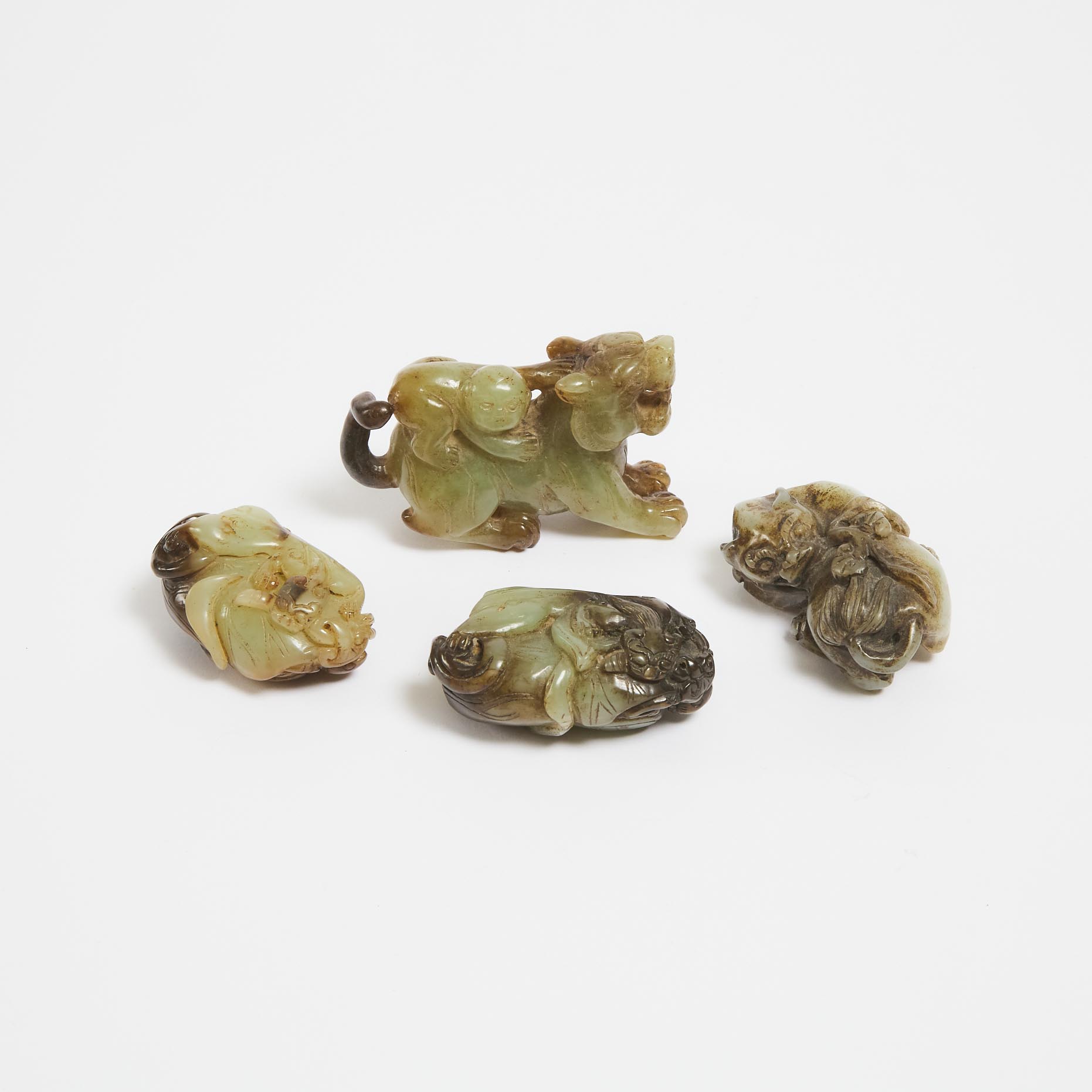 A Group of Four Celadon and Russet Jade Carvings of Beasts, 20th Century