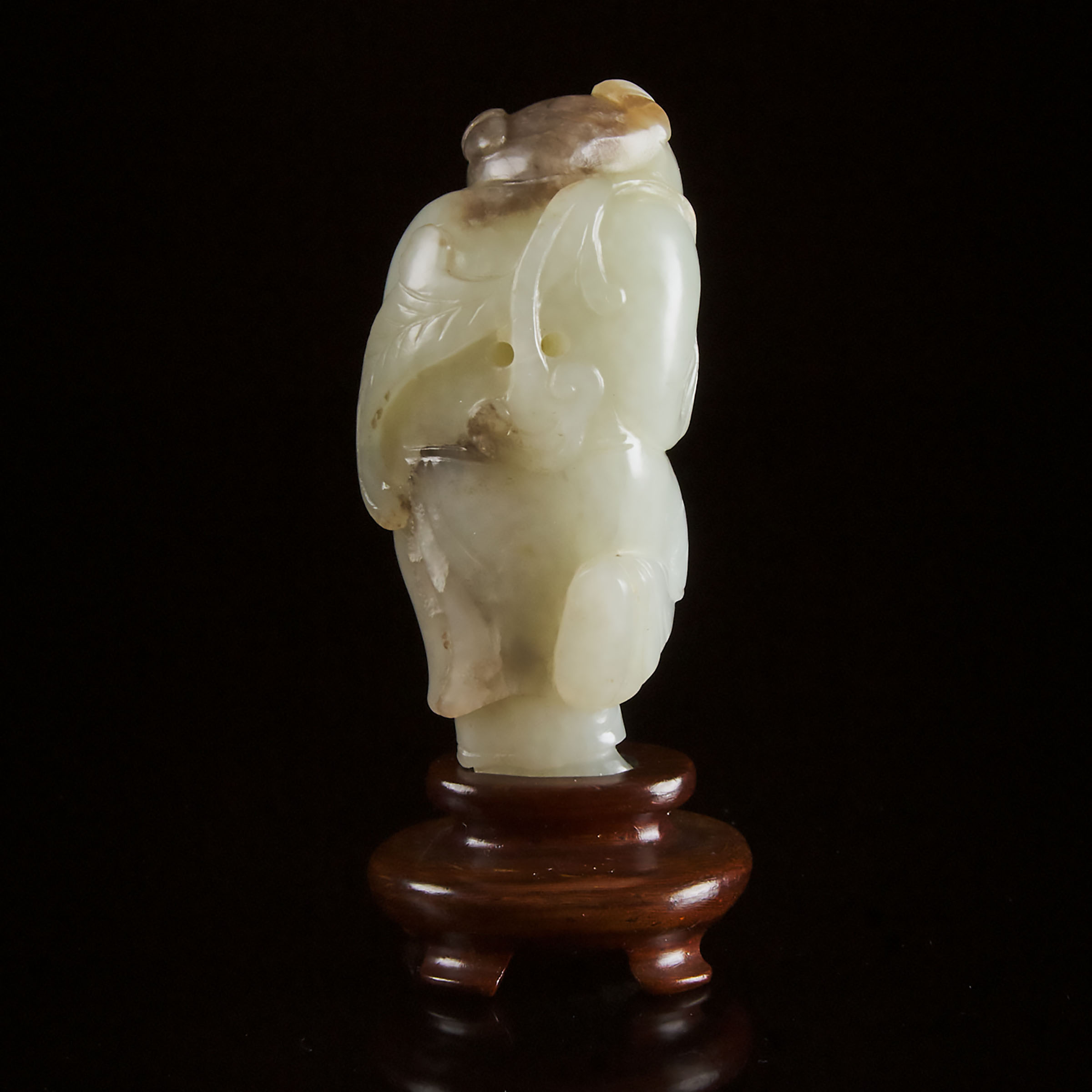 A White and Russet Jade Carving of a Boy Holding Lingzhi, Qing Dynasty, Late 19th Century