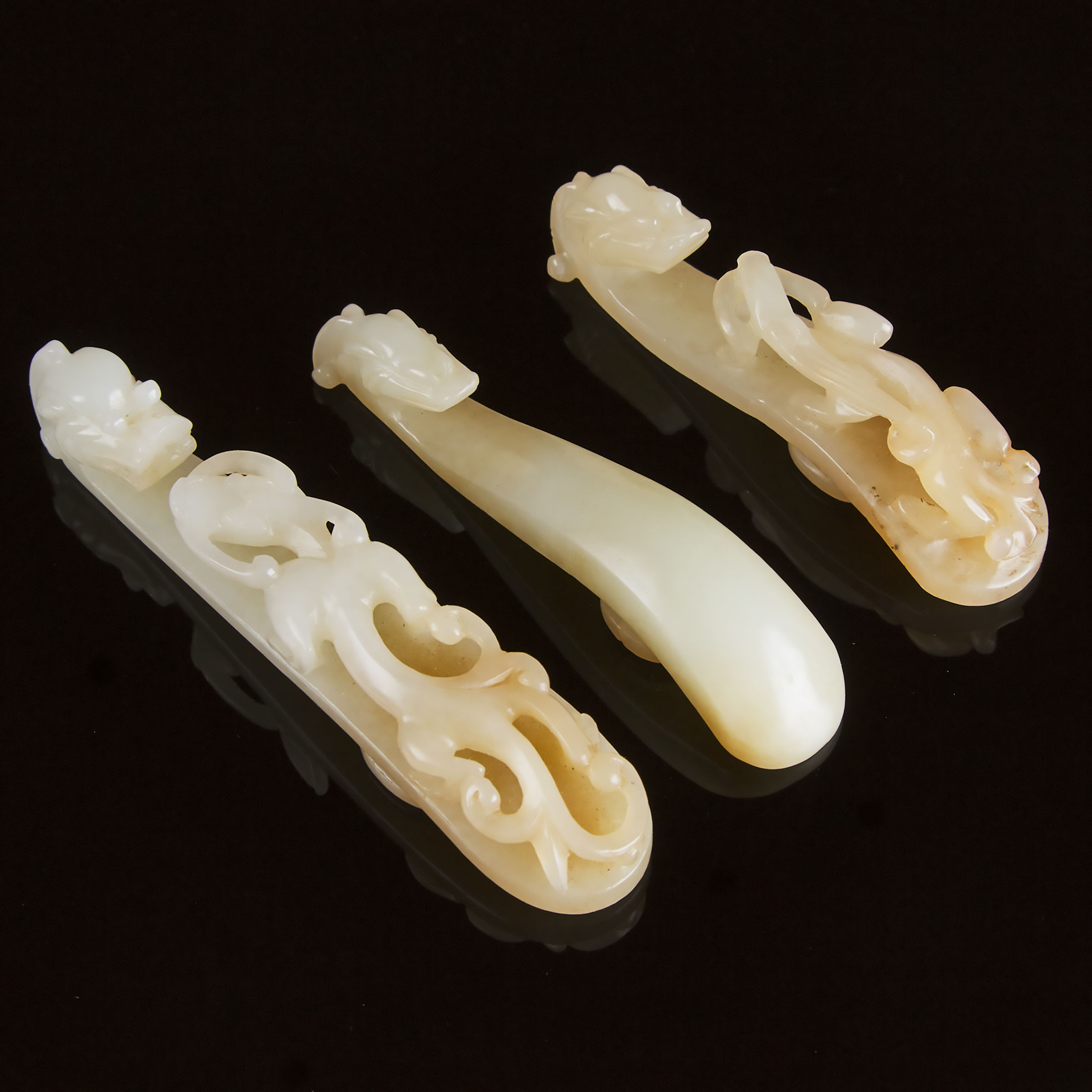 A Group of Three White and Pale Russet Jade Belt Hooks