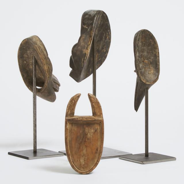 Three Dan Passport Masks, Ivory Coast/Liberia, West Africa, early to mid 20th century together with a Toma Passport Mask, Guinea/Liberia, West Africa, mid to late 20th century