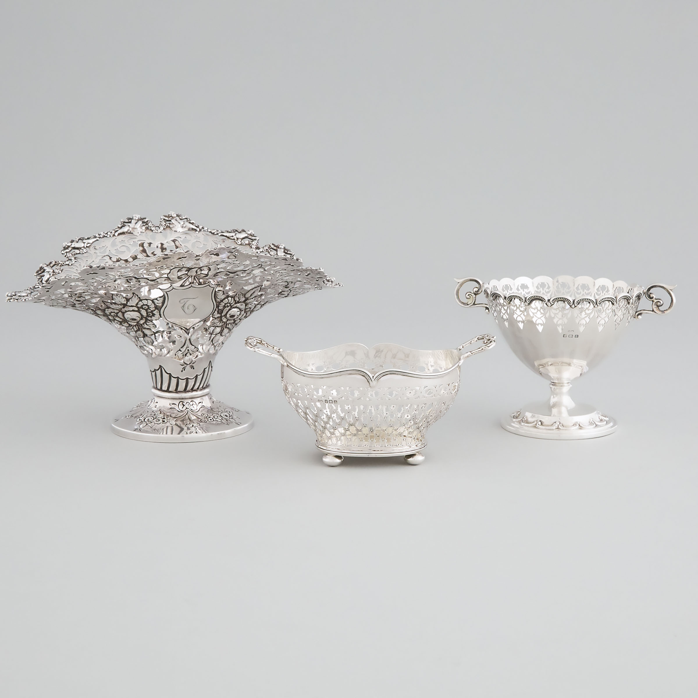 Three Edwardian and Later English Silver Pierced Baskets, George Nathan & Ridley Hayes, Chester, 1904, and Henry Matthews, Birmingham, 1923 and 1929