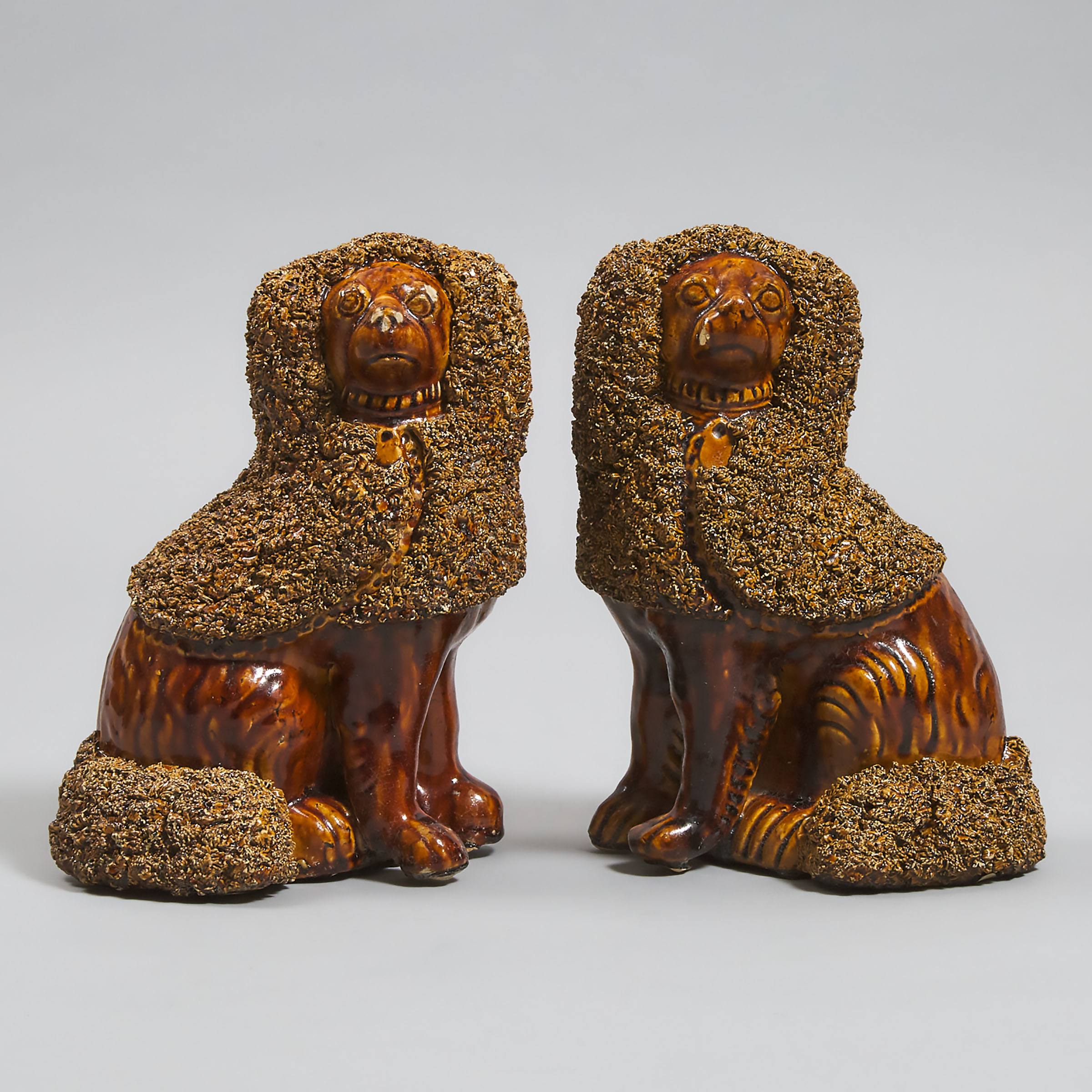 Pair of American 'Rockingham' Treacle Glazed Figures of Seated Spaniels, 19th century 