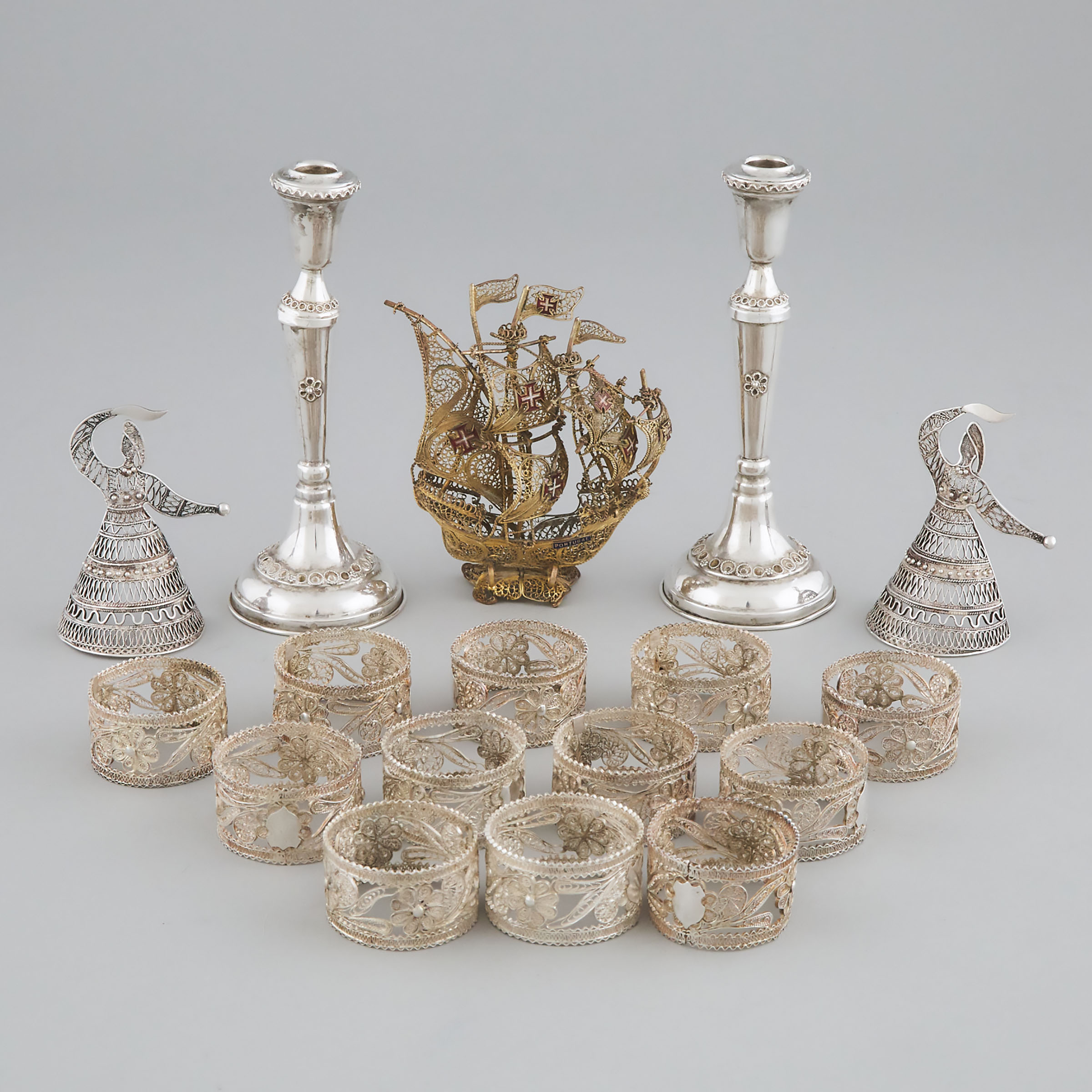 Pair of Silver Filigree Candlesticks, Twelve Napkin Rings, Pair of Figures and a Small Nef, 20th century