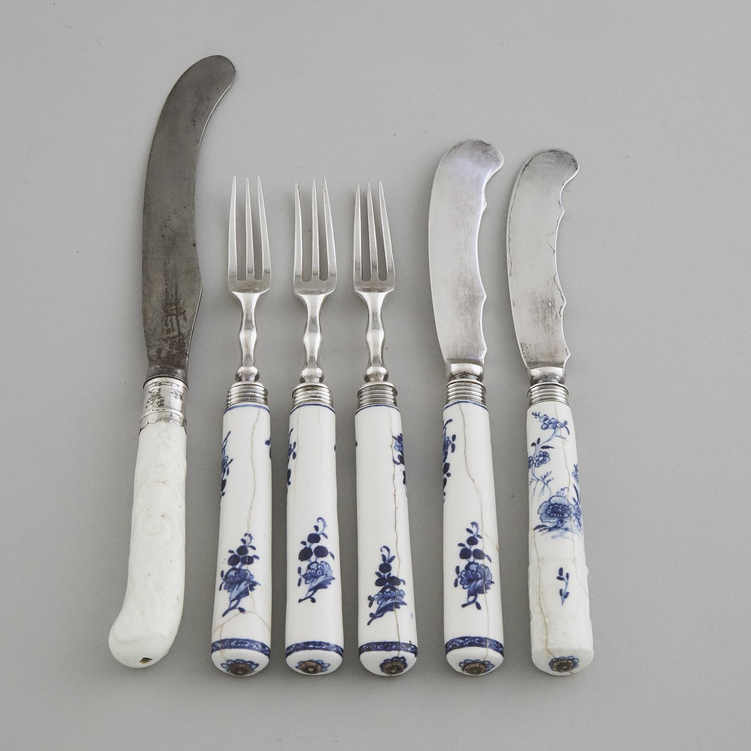French Porcelain Moulded and White Glazed Knife Handle, probably Saint Cloud, c.1740, together with Five Blue Painted Handles, probably Tournai, c.1775