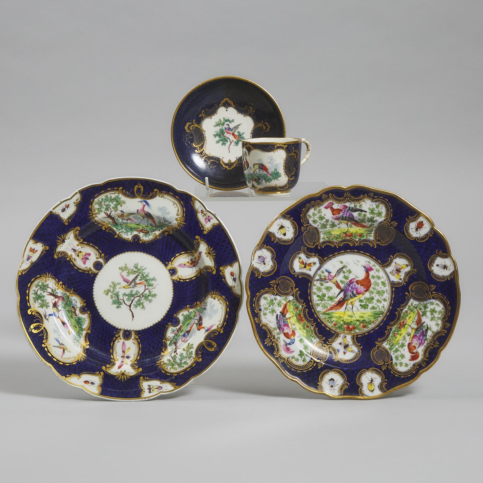 Two Samson 'Worcester' Scale Blue Ground Exotic Bird Plates and a Cup and Saucer, c.1900