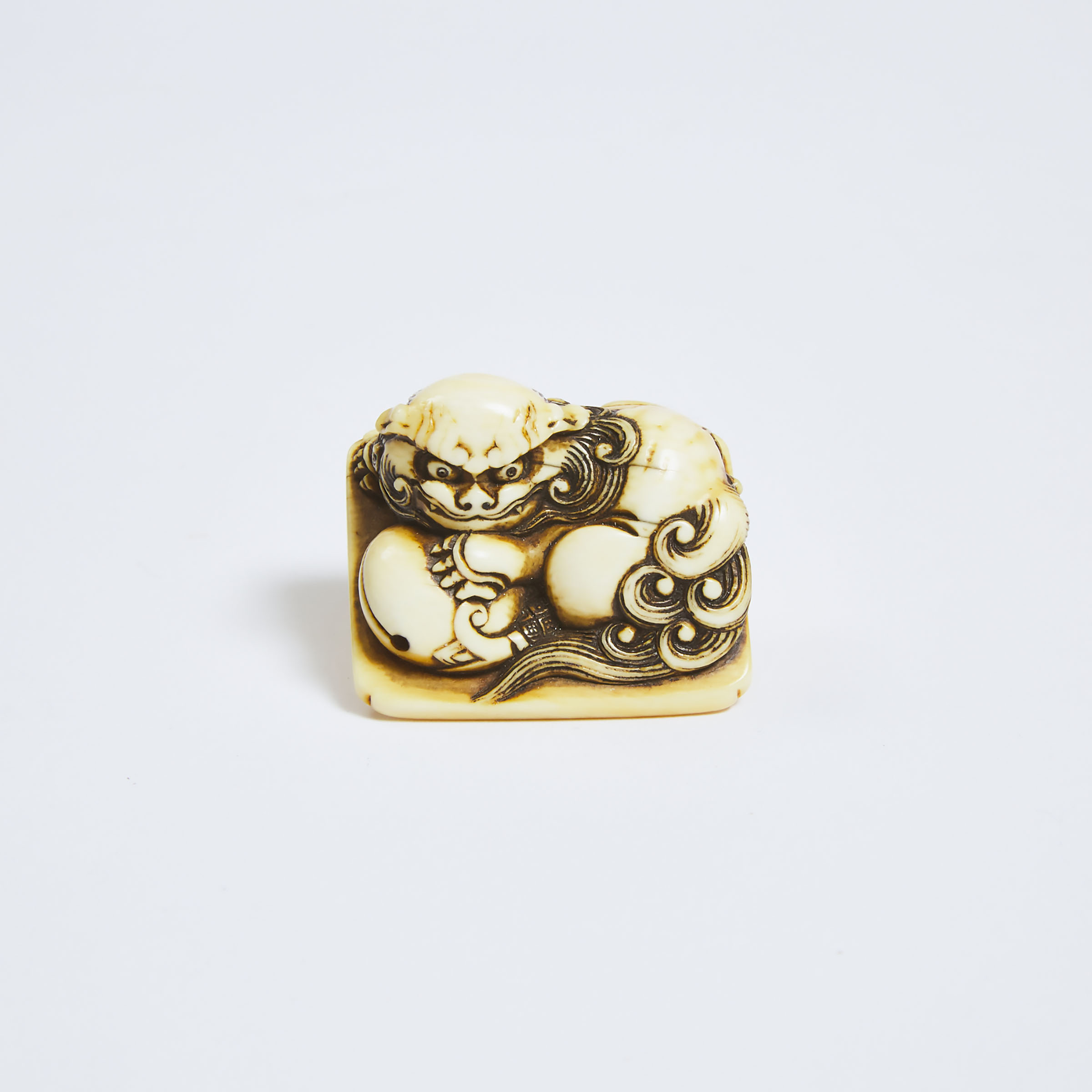 An Ivory Netsuke of a Recumbent Shishi, Mid 19th Century