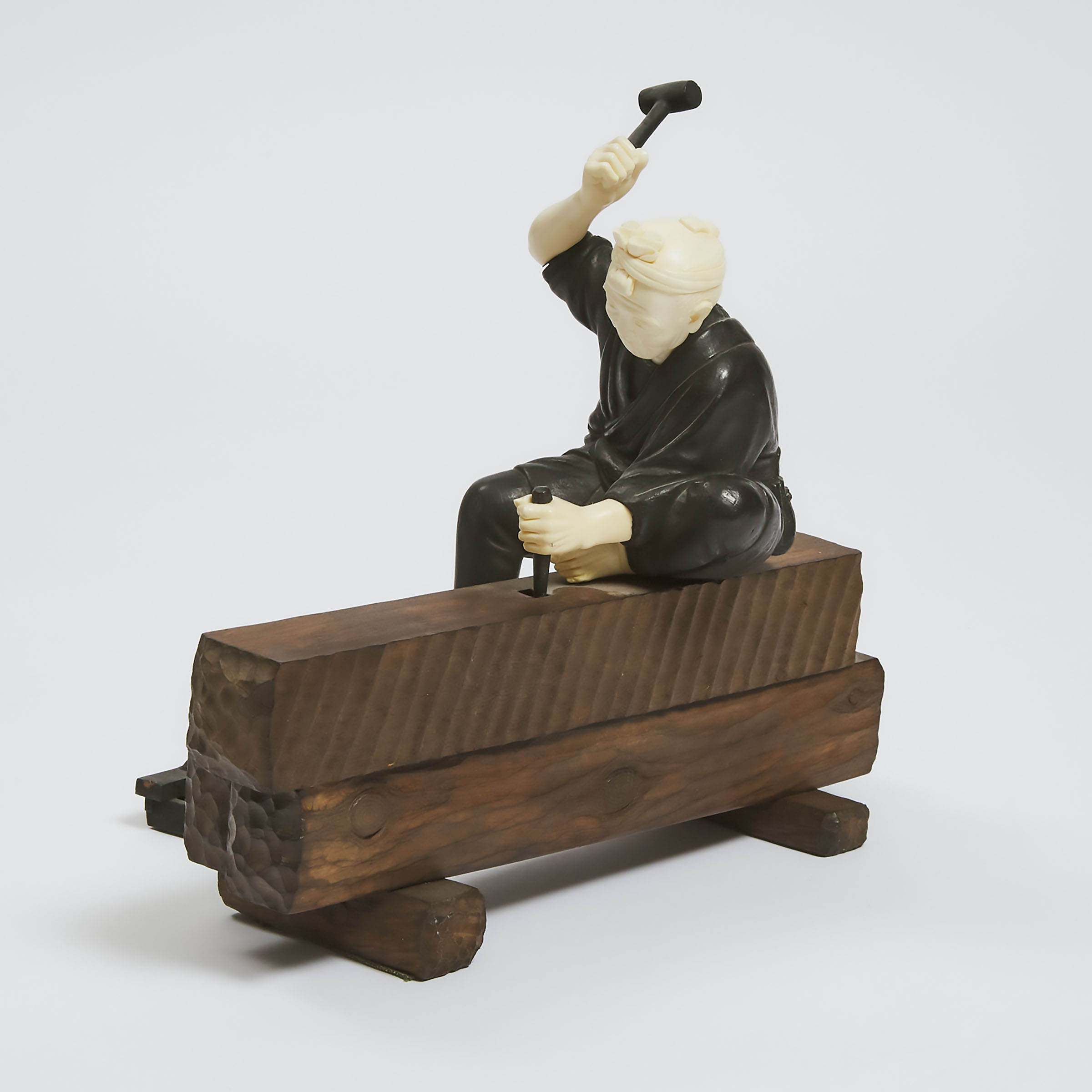 An Ivory, Wood and Bronze Okimono of a Carpenter, Meiji Period (1868-1912)