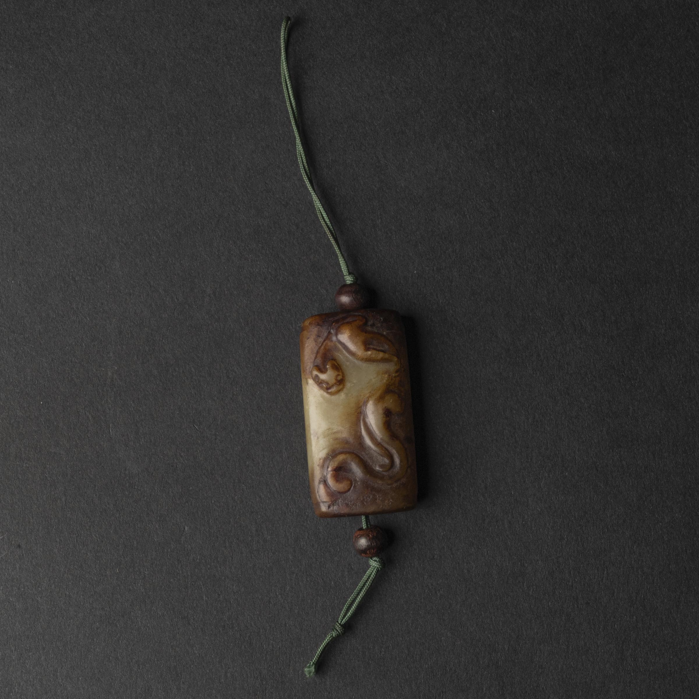 A Celadon and Russet 'Chilong' Tubular Pendant, Ming Dynasty (1368-1644)