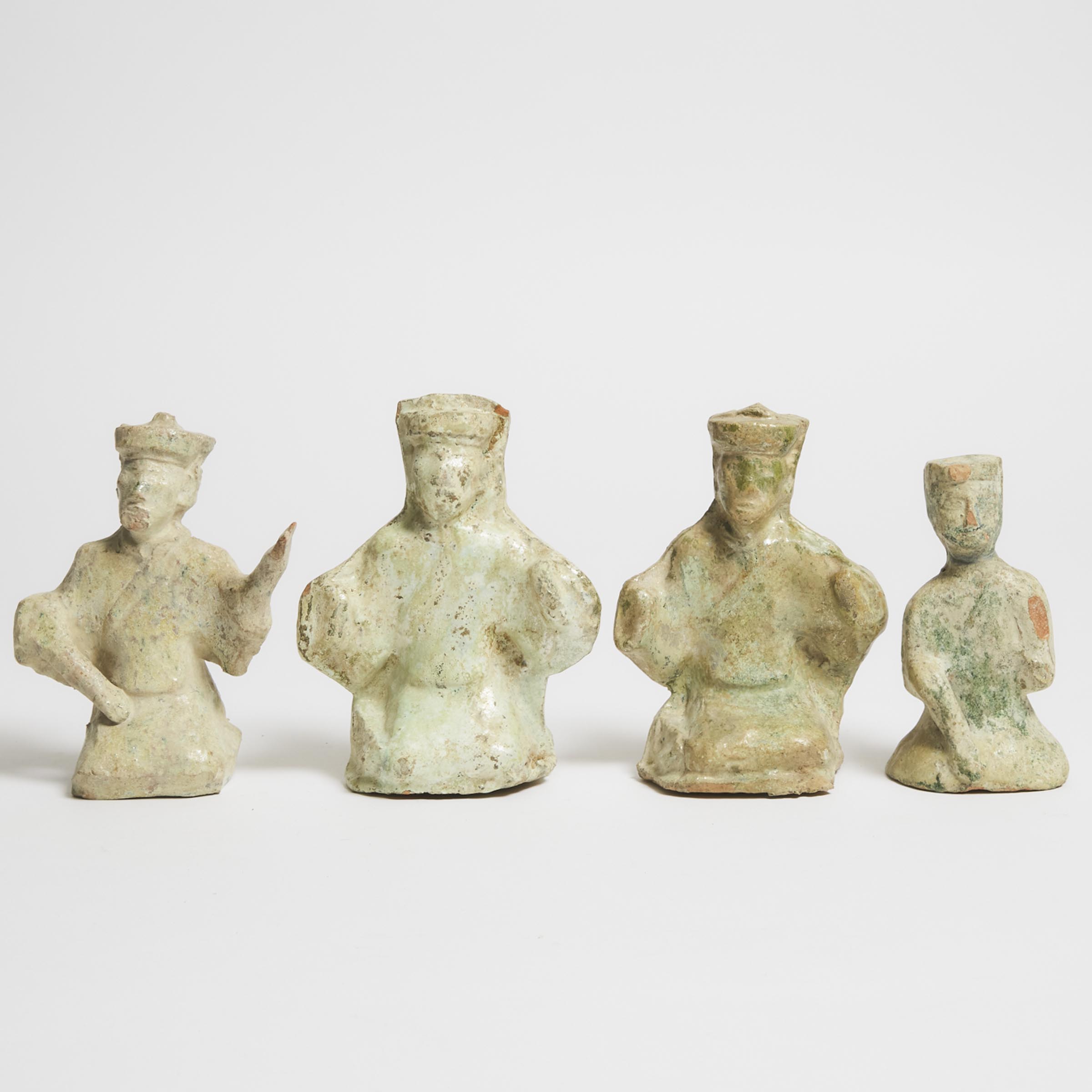 A Group of Four Green-Glazed Pottery Seated Figures, Han Dynasty (206 BC-AD 220)