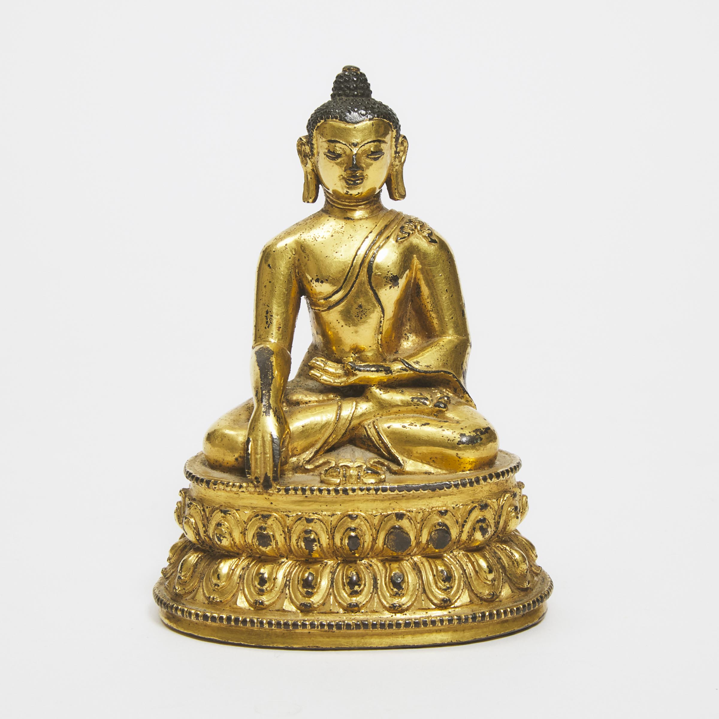 A Gilt Copper Alloy Figure of Seated Shakyamuni Buddha, Tibet, 15th Century