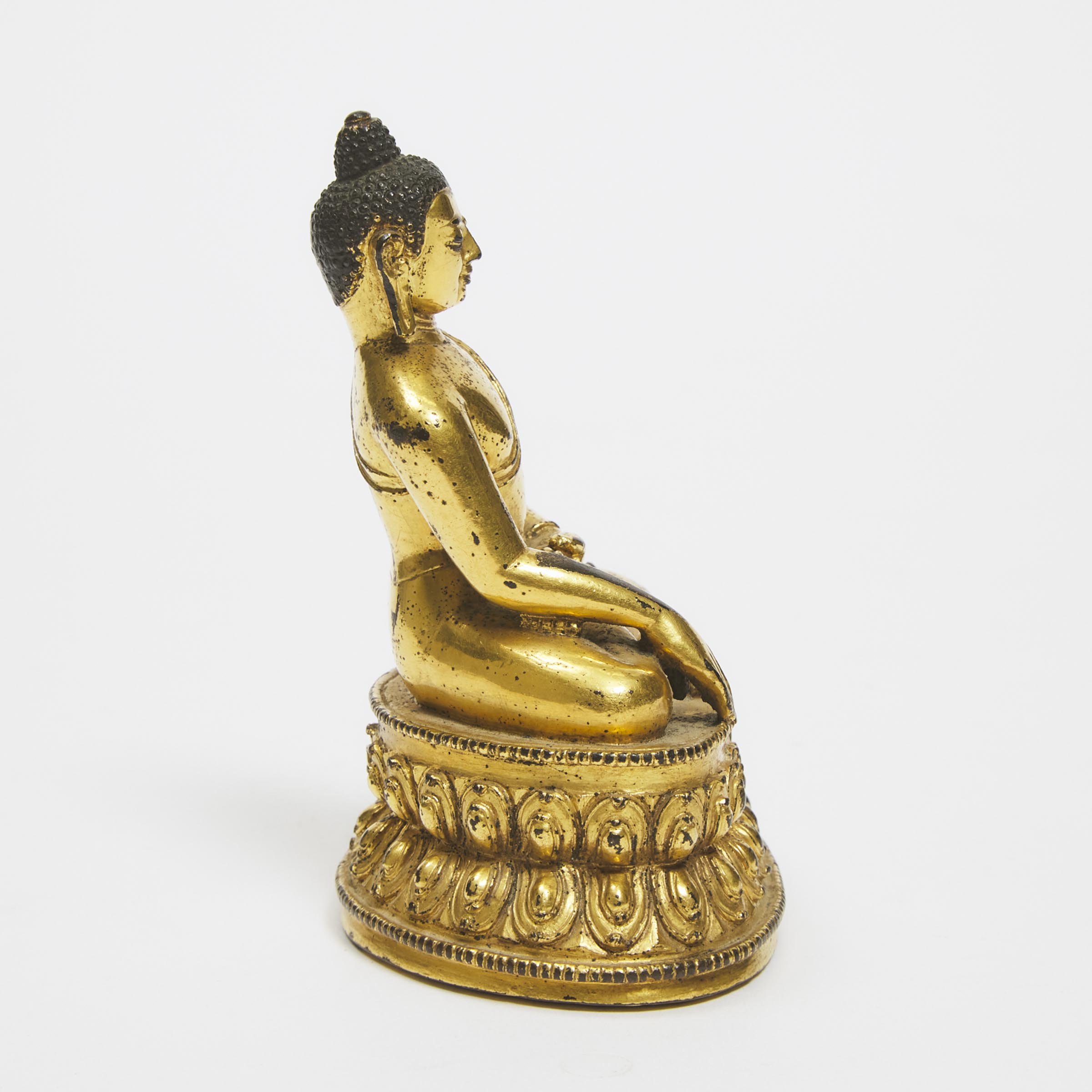 A Gilt Copper Alloy Figure of Seated Shakyamuni Buddha, Tibet, 15th Century