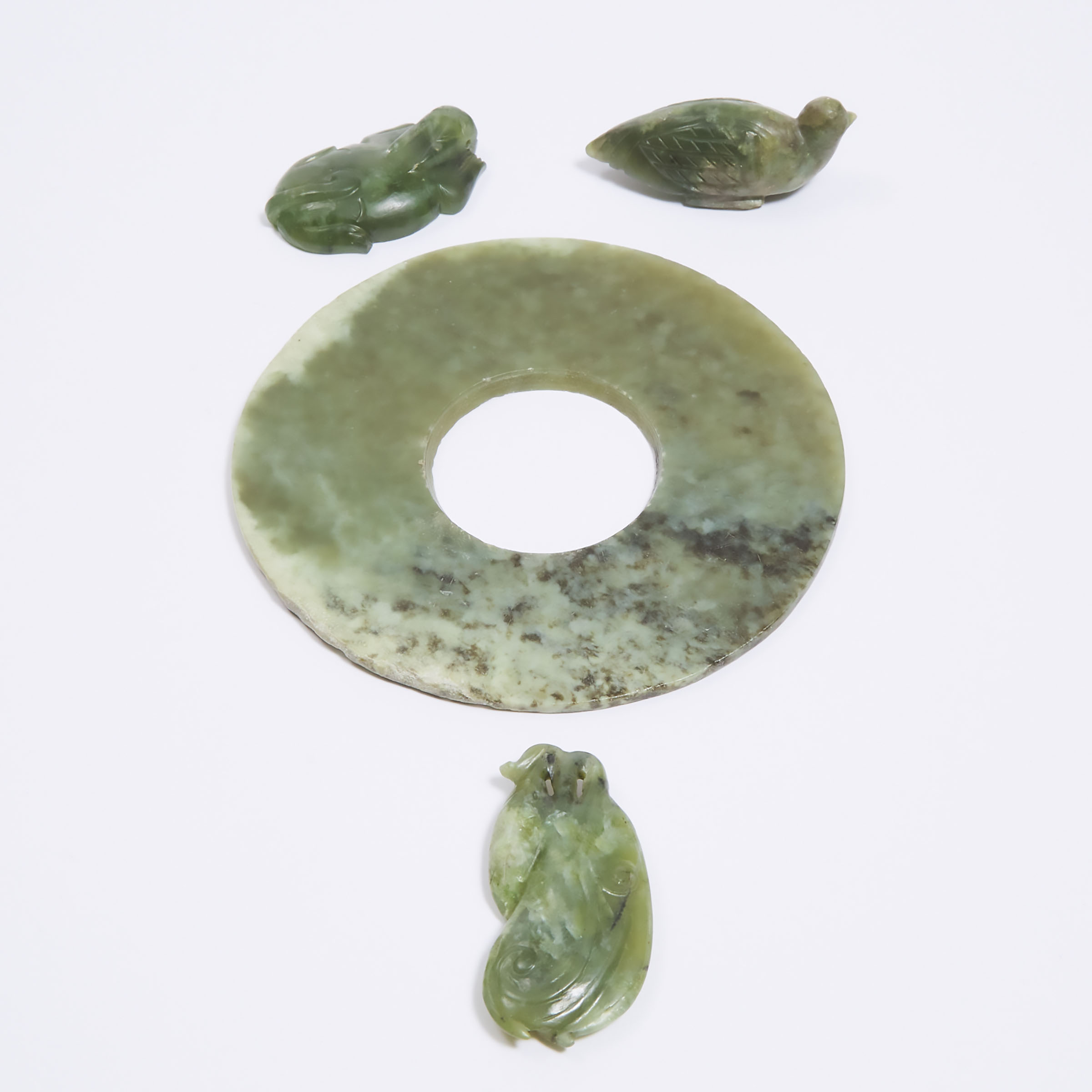 A Green Hardstone Bi Disc, Together With Three Carvings, 19th Century and Later