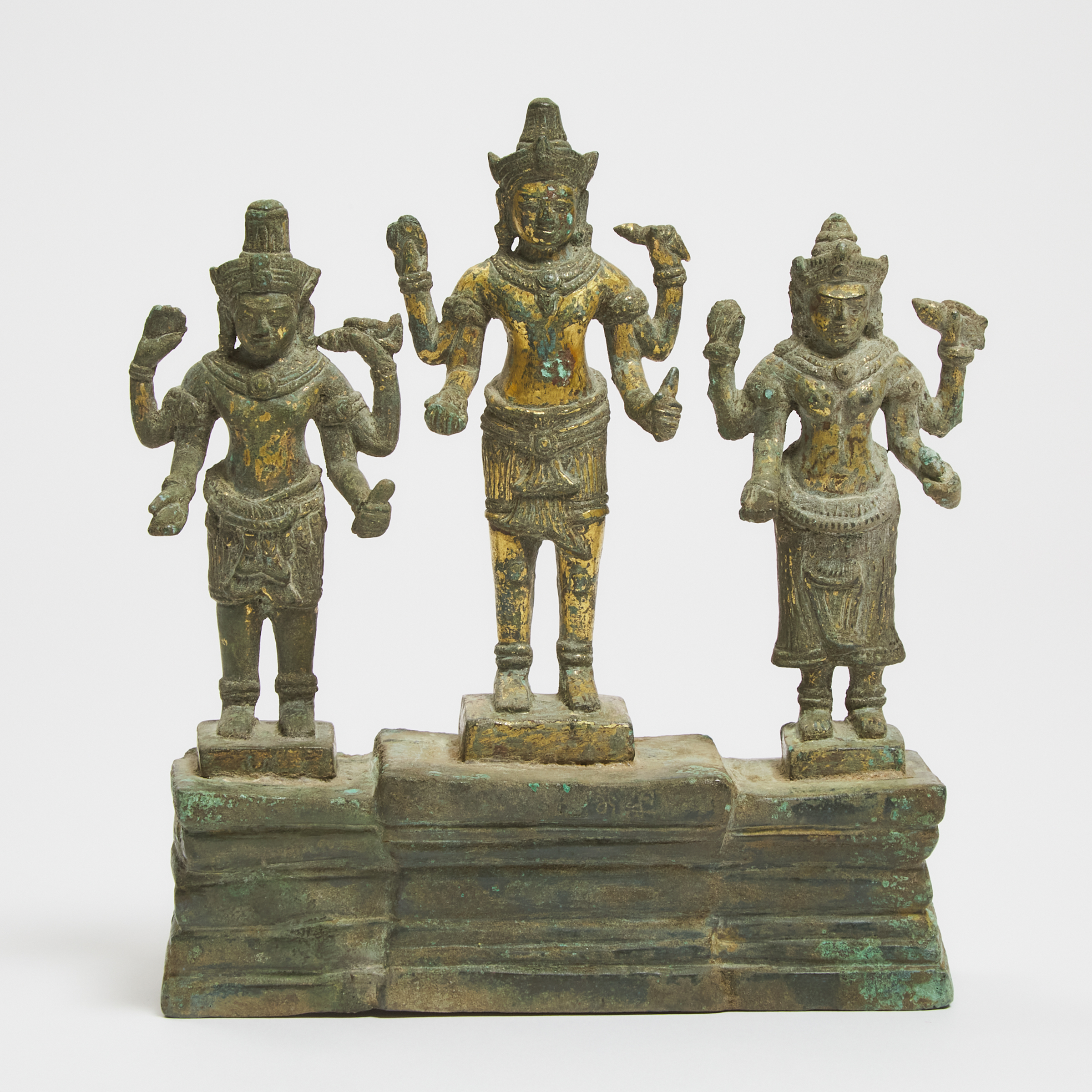 A Khmer Bayon Style Gilt Bronze Triad of Shiva, Vishnu and Devi, With Inscription, 13th Century