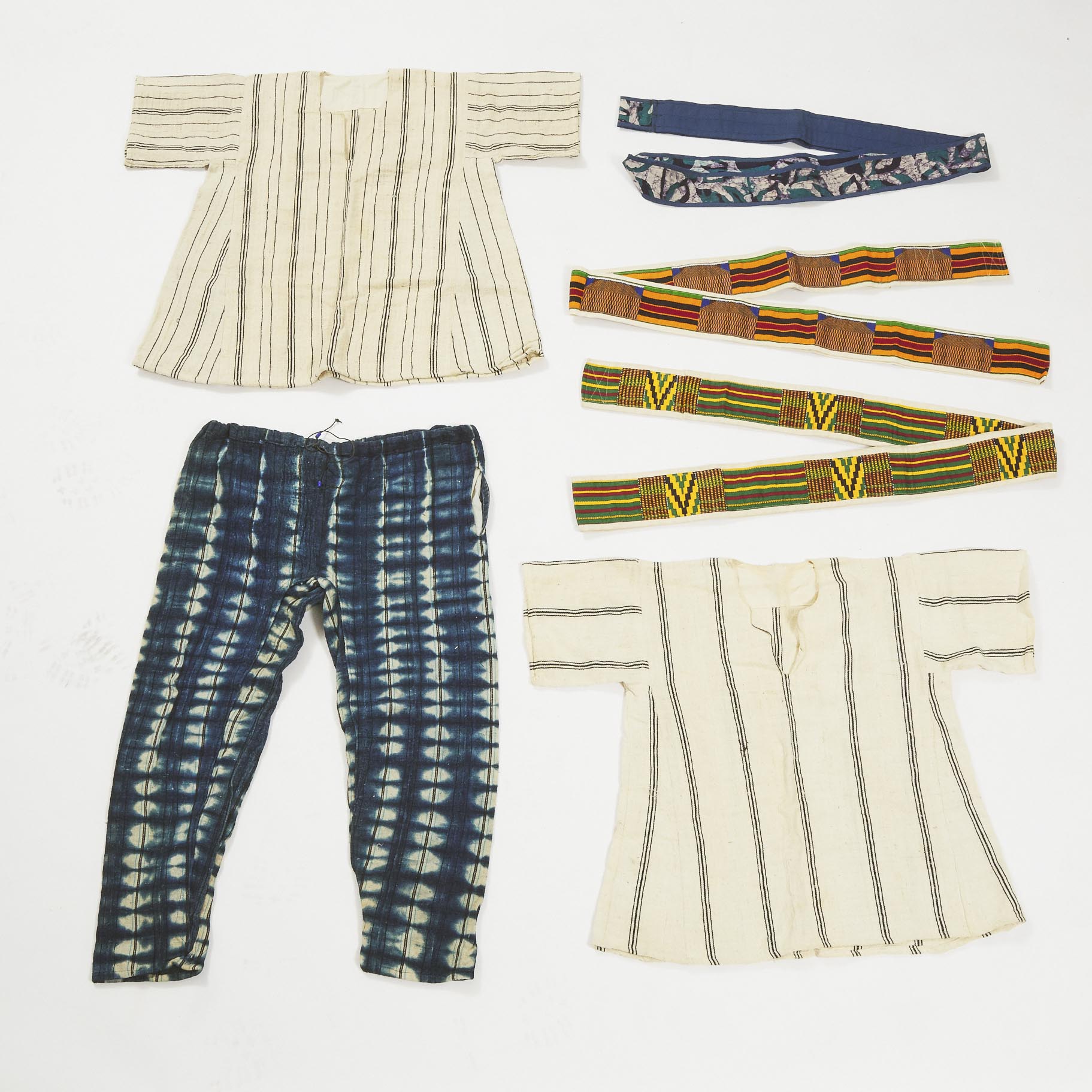 Group of Six African Textiles including two shirts, pair of pants, two Kente cloth sashes together with a dyed sash