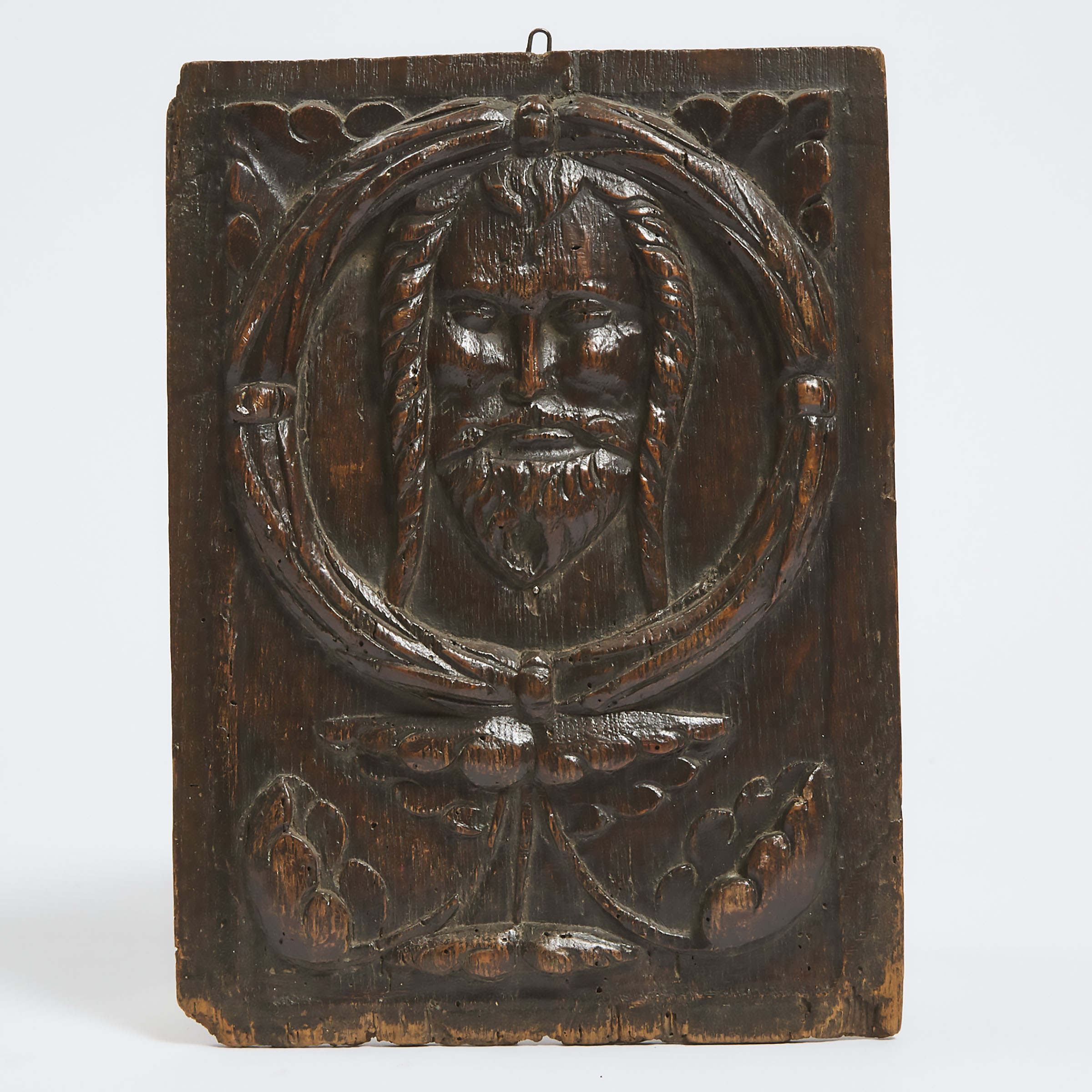 Relief Carved Oak Panel With a Mask of Jesus Within a Wreath, 16th century