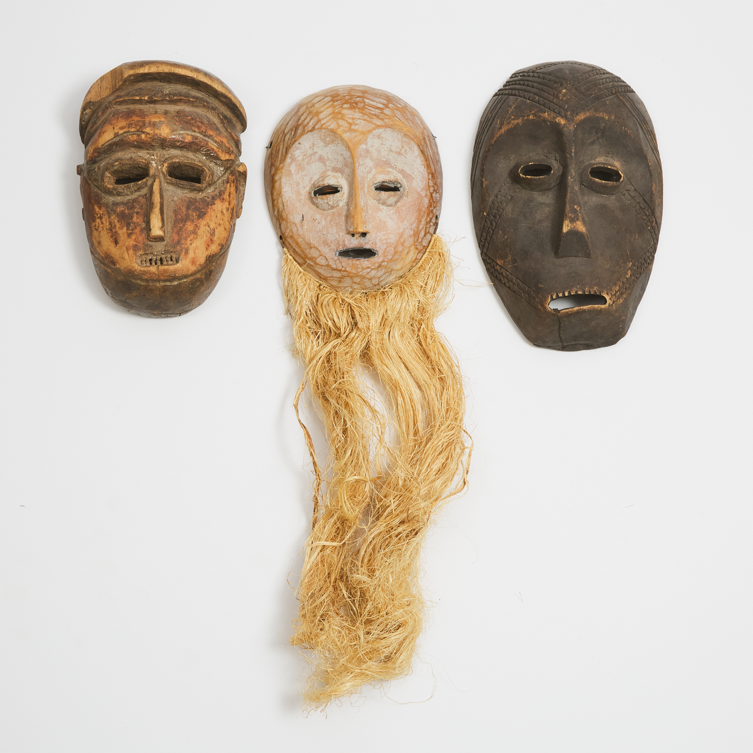 Group of Three African Masks including two Lega masks, 20th century