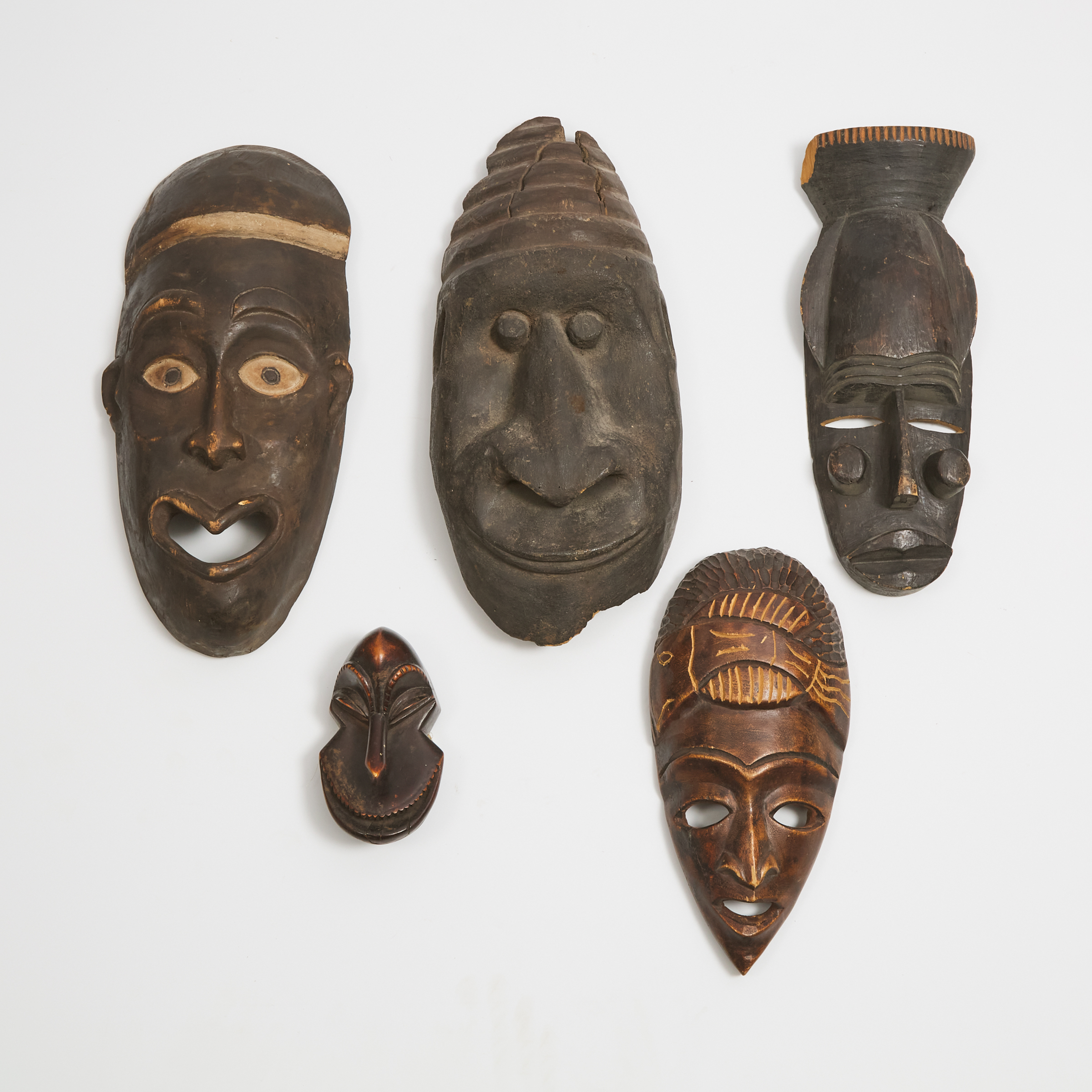 Group of Five African Masks including two Makonde and one miniature Hemba monkey mask, 20th century