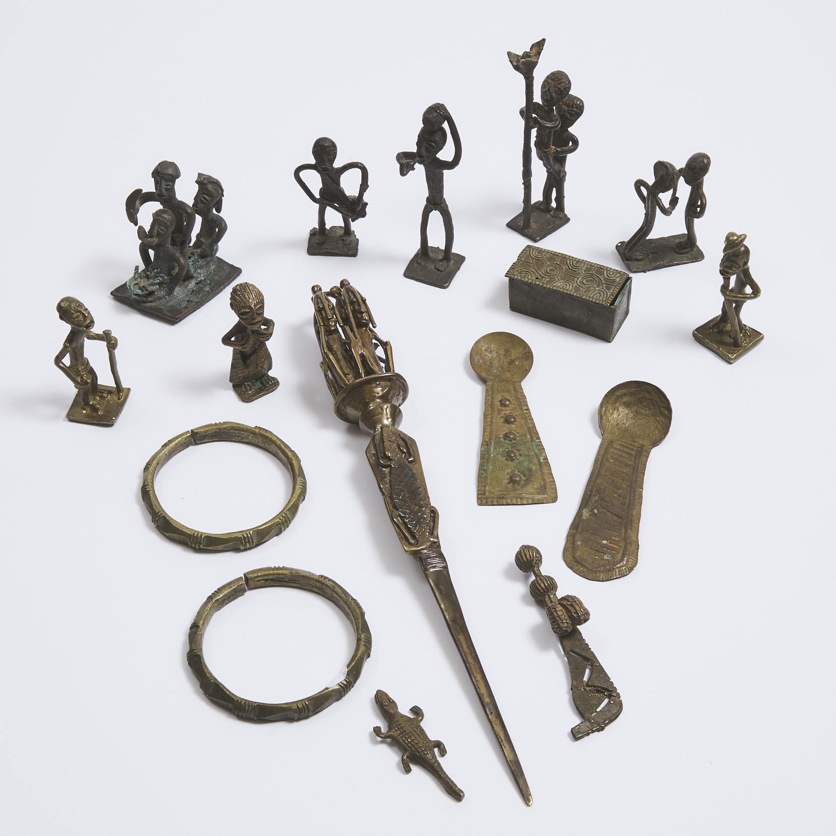 A group of 13 Akan Brass Artifacts including ten figural goldweights, two gold dust spoons and box, two African bangles and a letter opener, 19th/20th century
