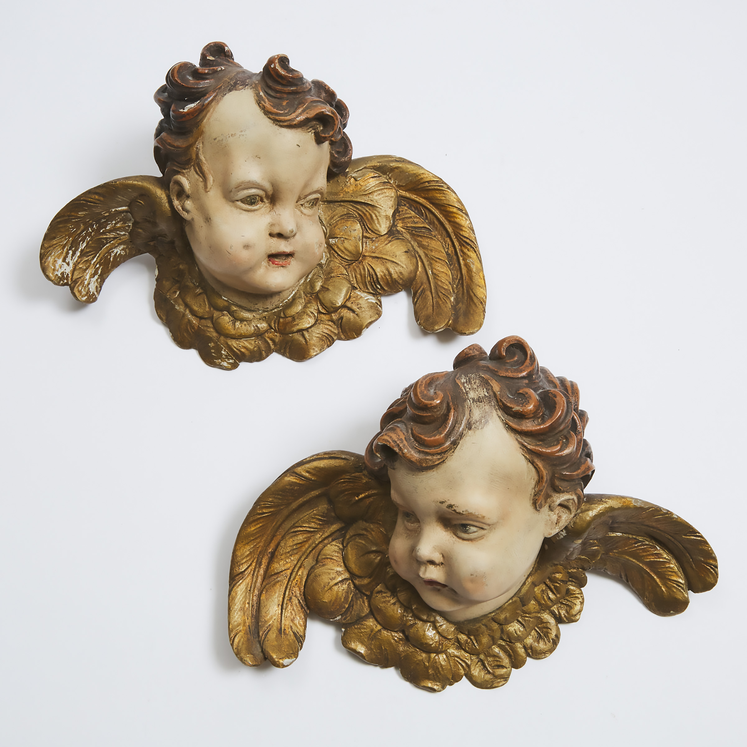 Pair of Italian Baroque Carved, Polychromed and Parcel Gilt Winged Cherubic Heads, 19th century