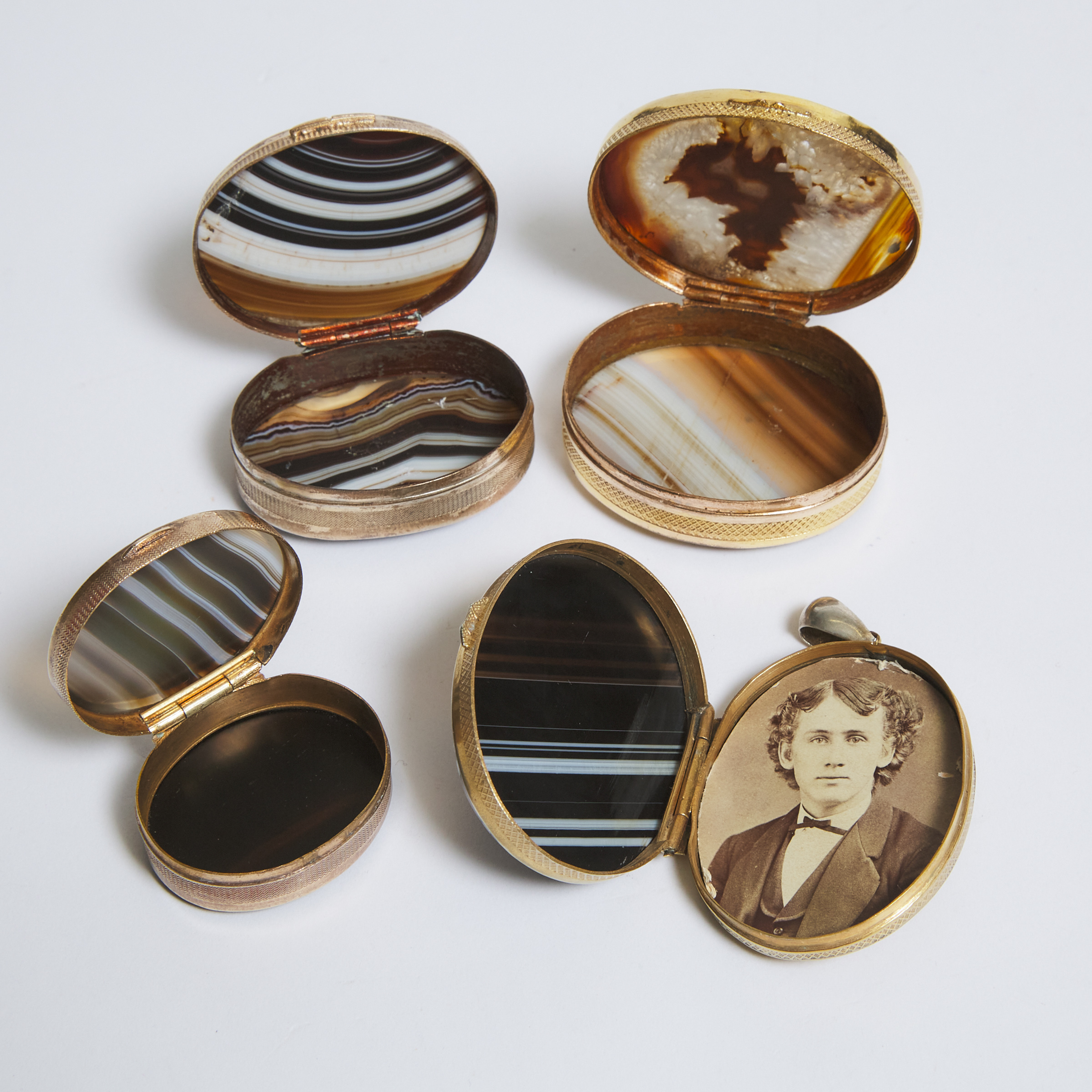 Three Italian Oval Agate Mounted Gilt Metal Dresser Boxes and a Locket Pendant, early 20th century
