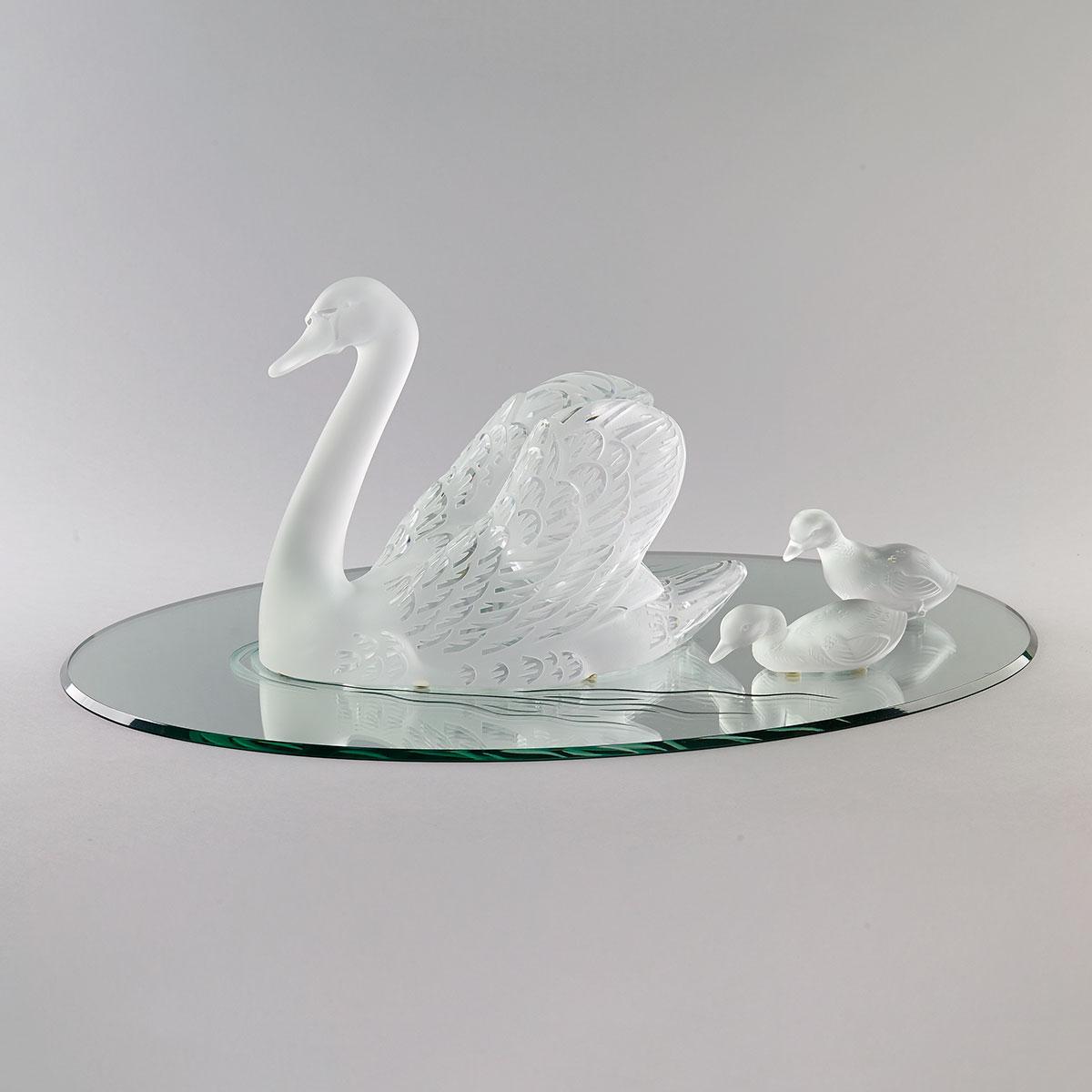 ‘Cygne, Tête Haute’, Lalique Moulded and Partly Frosted Glass Swan with Two Baccarat Cygnets on Mirror Plateau, 20th century