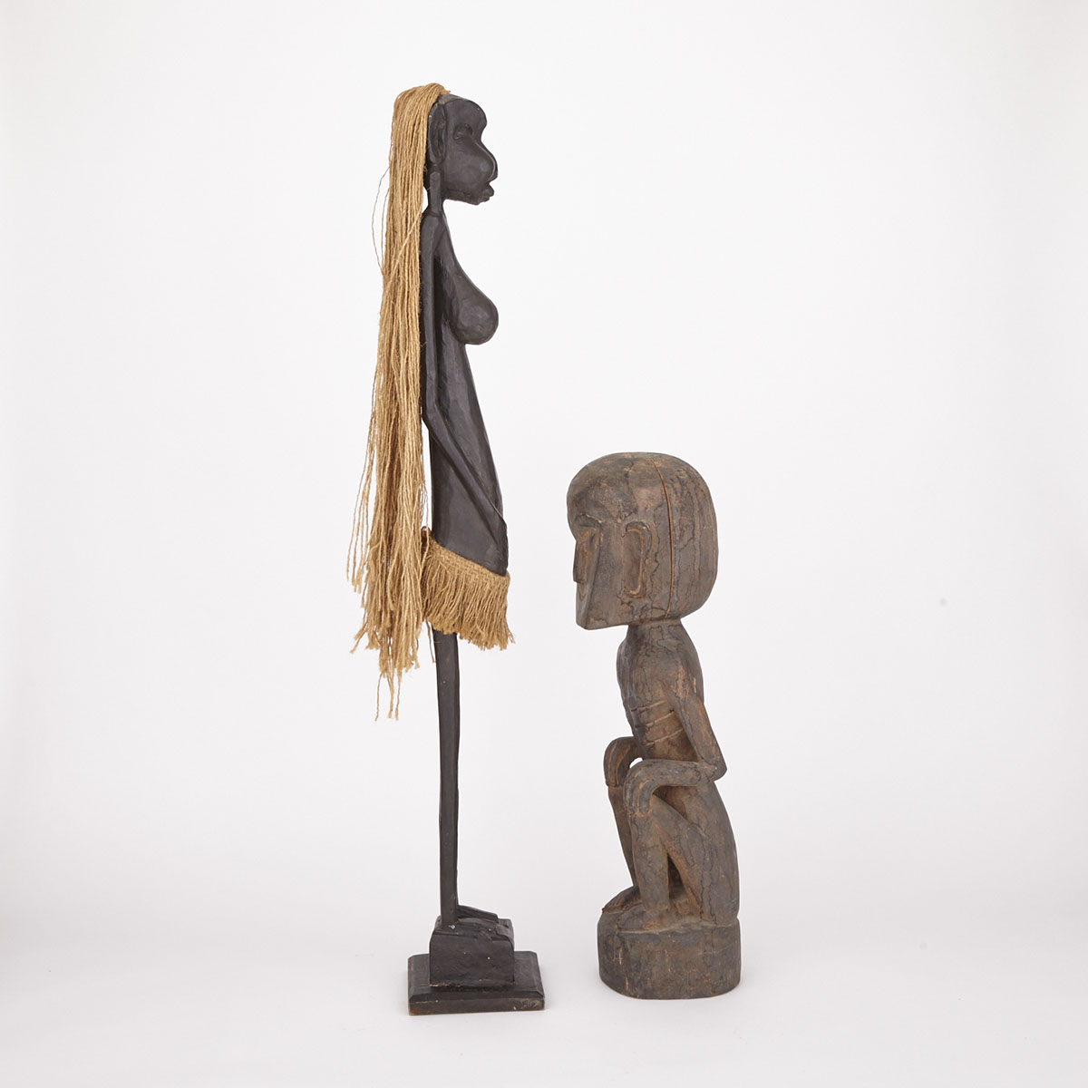 Carved Wood Male Fetish Figure together with a Carved Wood Female Figure with fiber hair and skirt, Africa, 20th/21st century