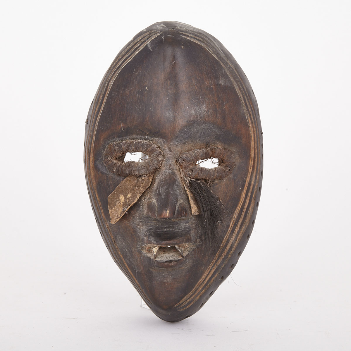 Dan Carved Wood Mask with applied hair, hide and metal decoration, West Africa, 20th century