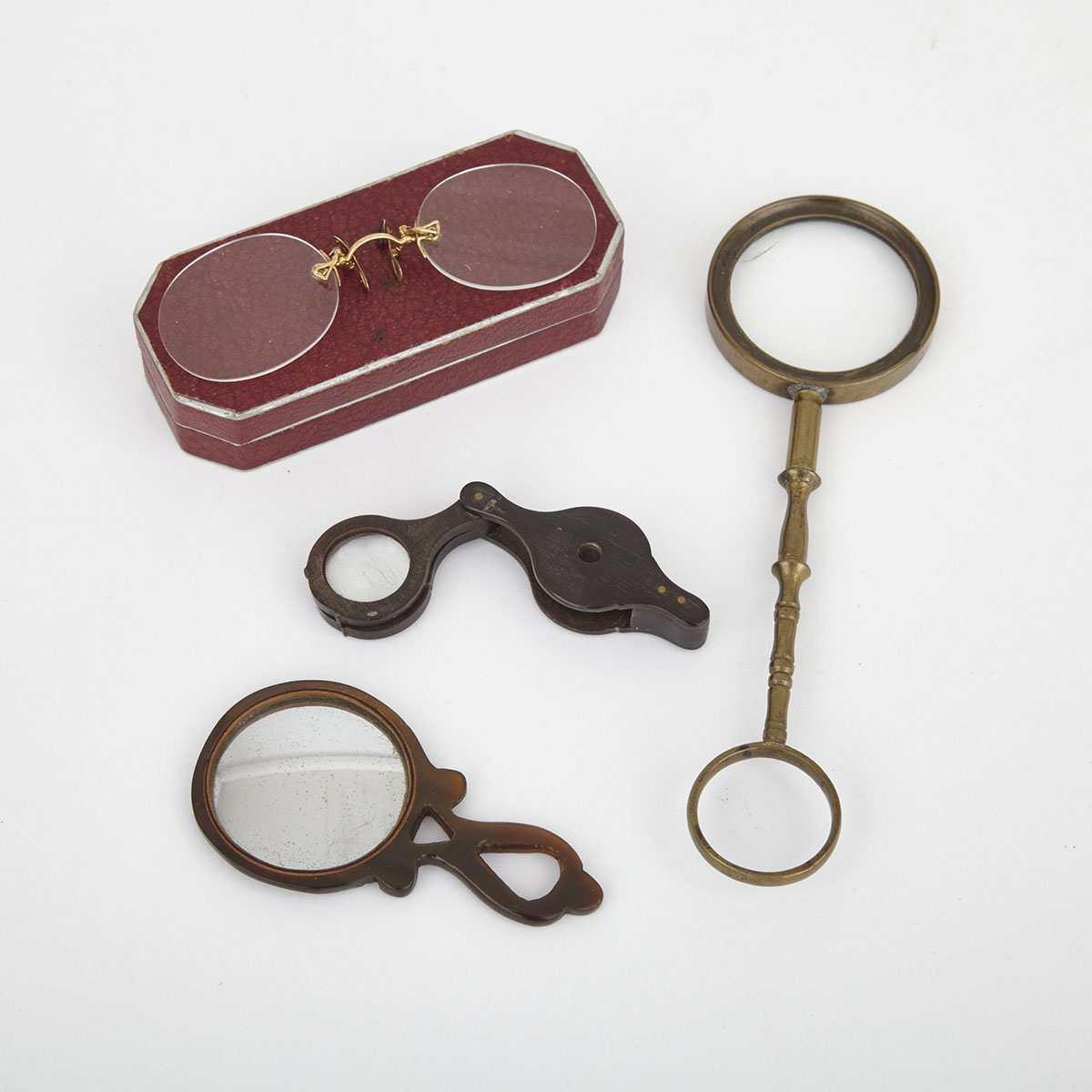 A Horn Magnifying Loupe, A Small Horn Convex Mirror A Large Brass Quizzing Glass and a Pair of Pinz Nez, 19th century