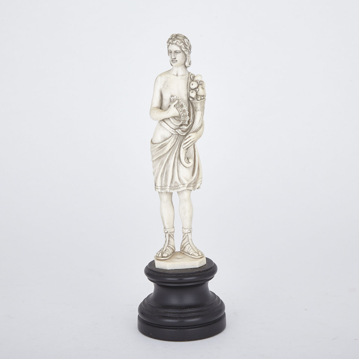 French Carved Ivory Figure of a Classical Young Man with Cornucopia and Crown, mid 20th century