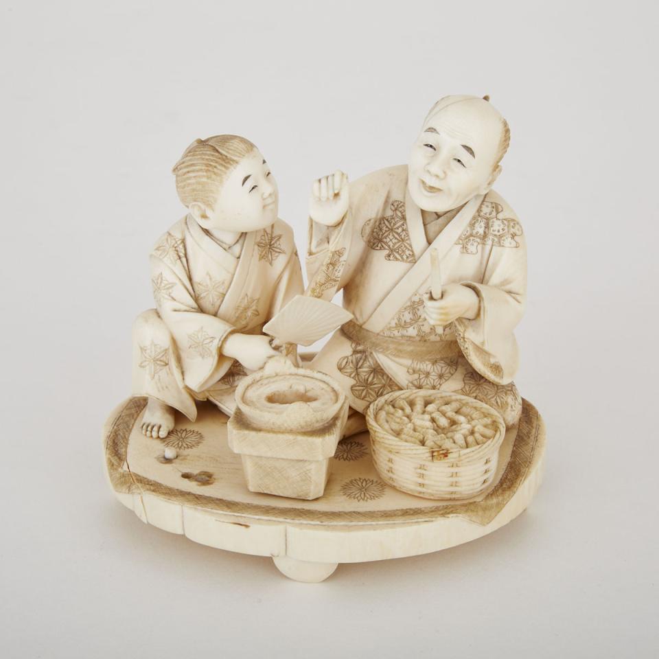A Carved Ivory Okimono of Two Men Cooking, Early 20th Century 