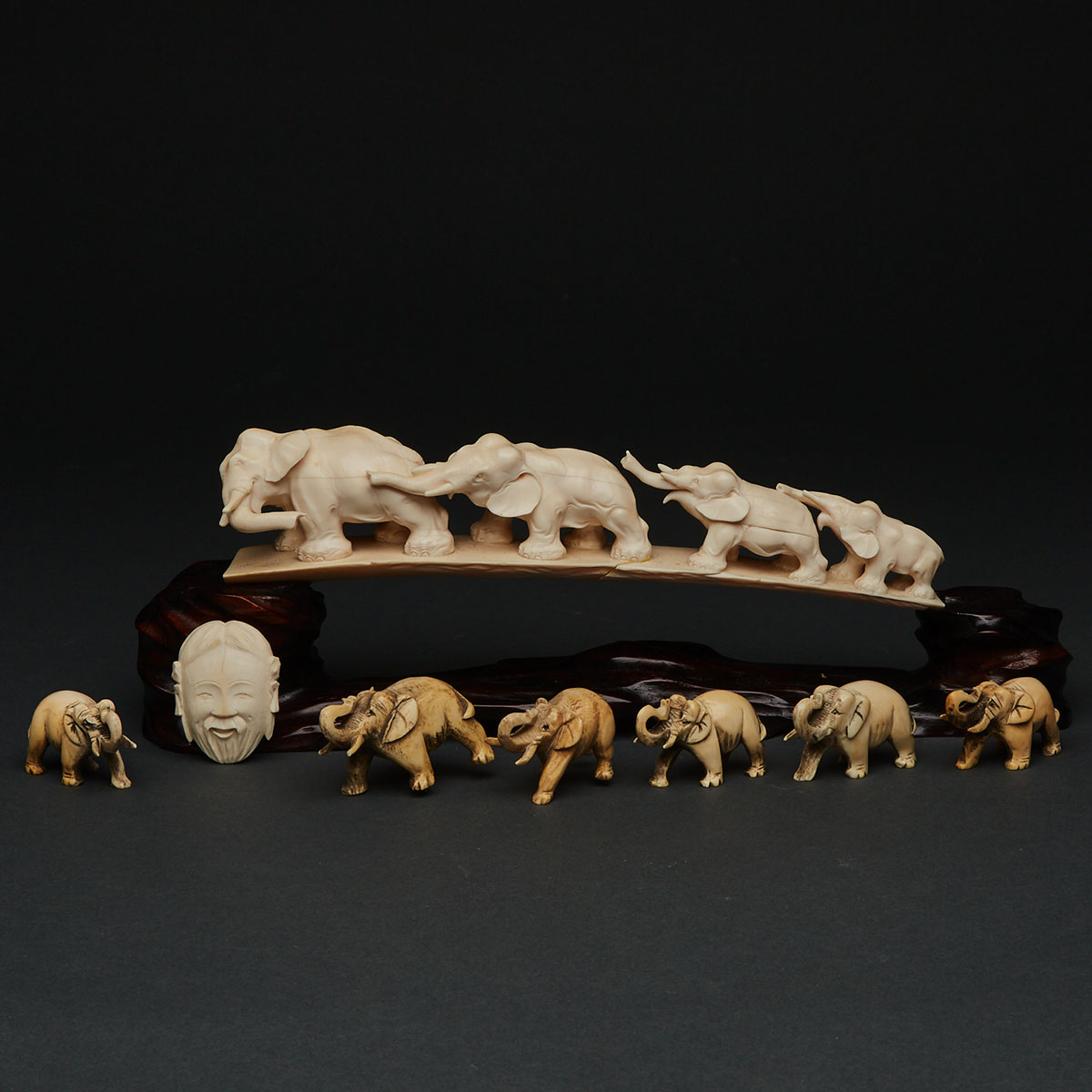 An Ivory Carved Tusk-Form Elephant Procession with Stand