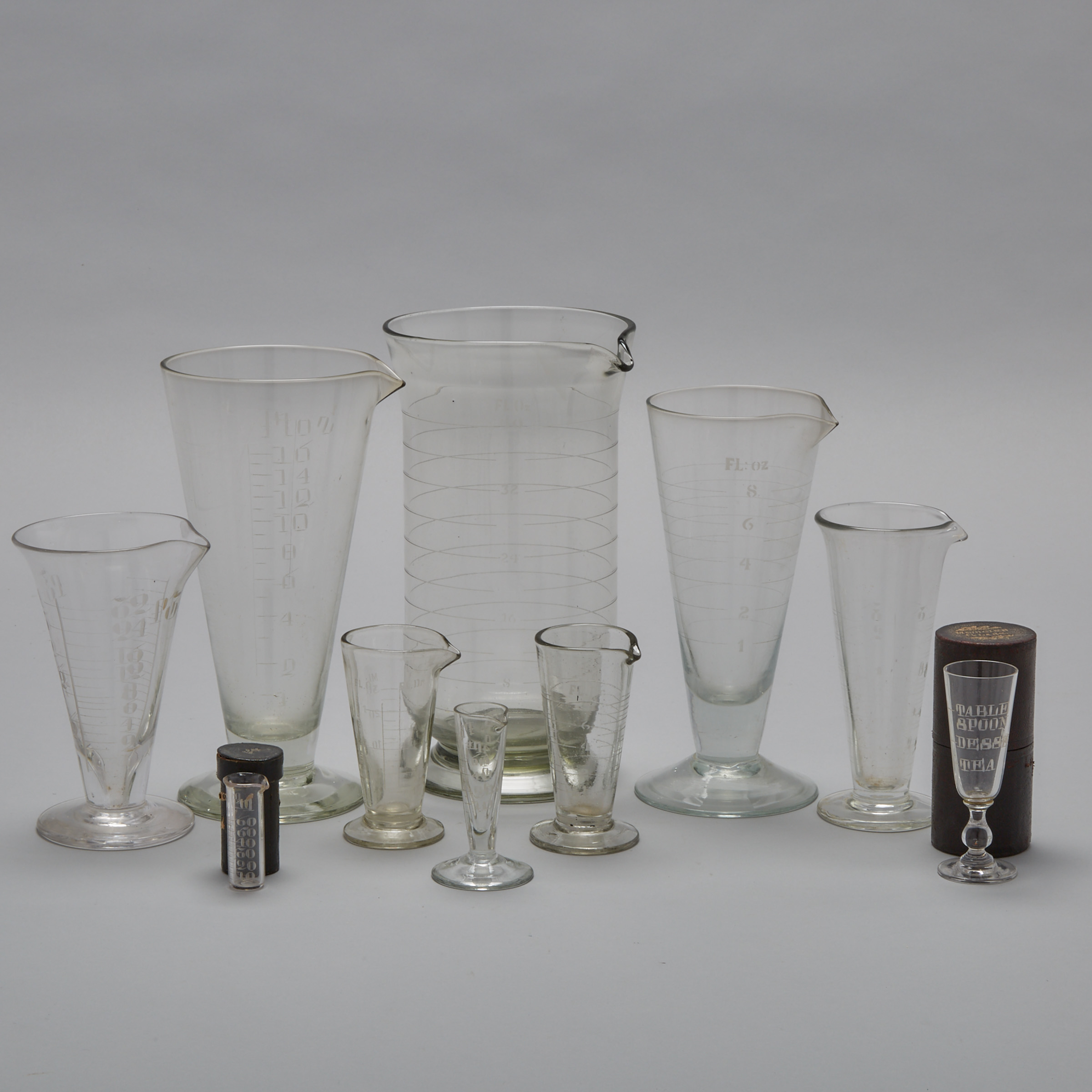 Group of Ten Pharmaceutical Glass Graduated Beakers and Vials, 19th/early 20th century